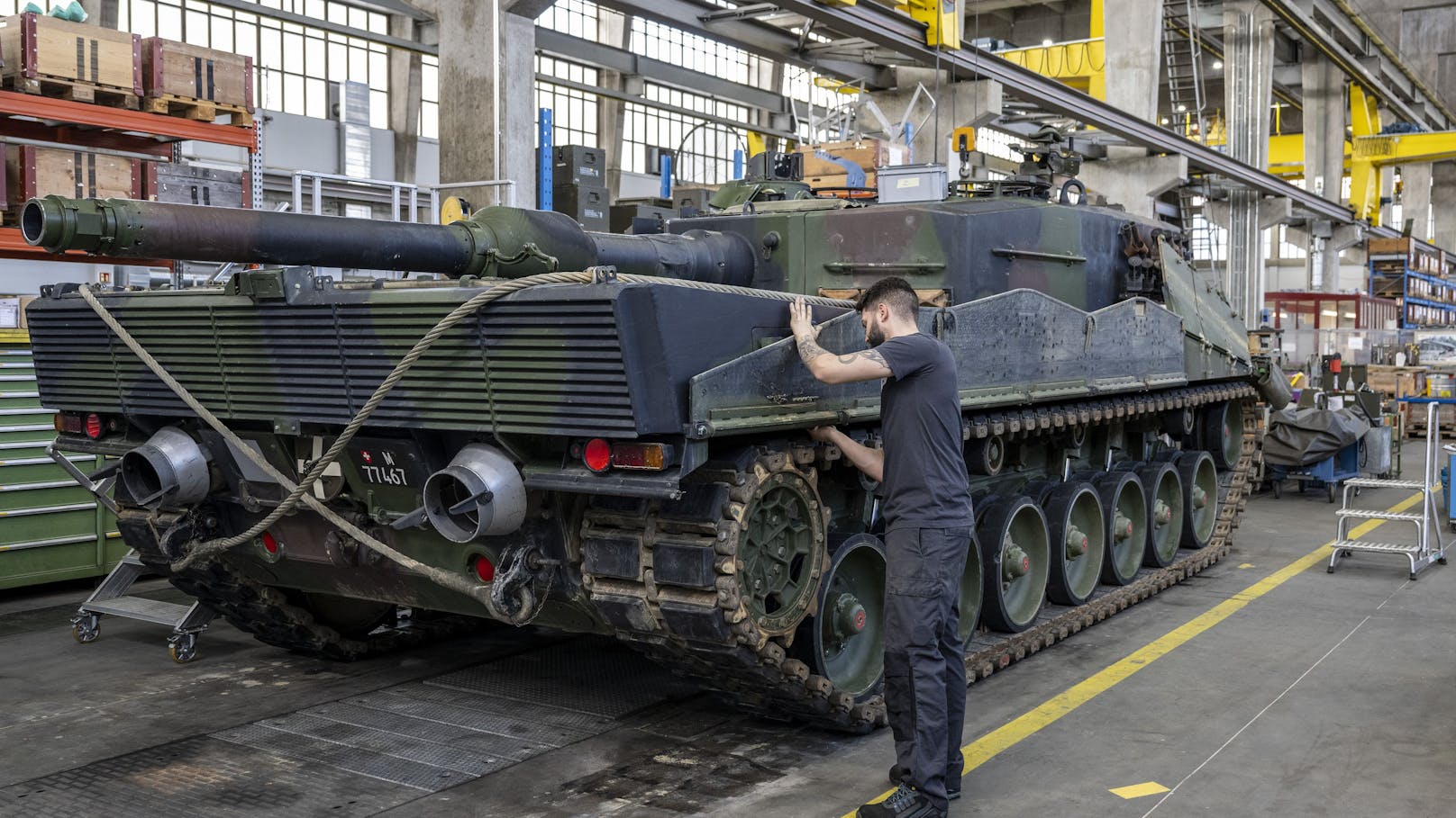Ein Mechaniker wartet die Raupen an einem Panzer vom Typ Leopard 2 in einer Wartungshalle der RUAG in Thun.