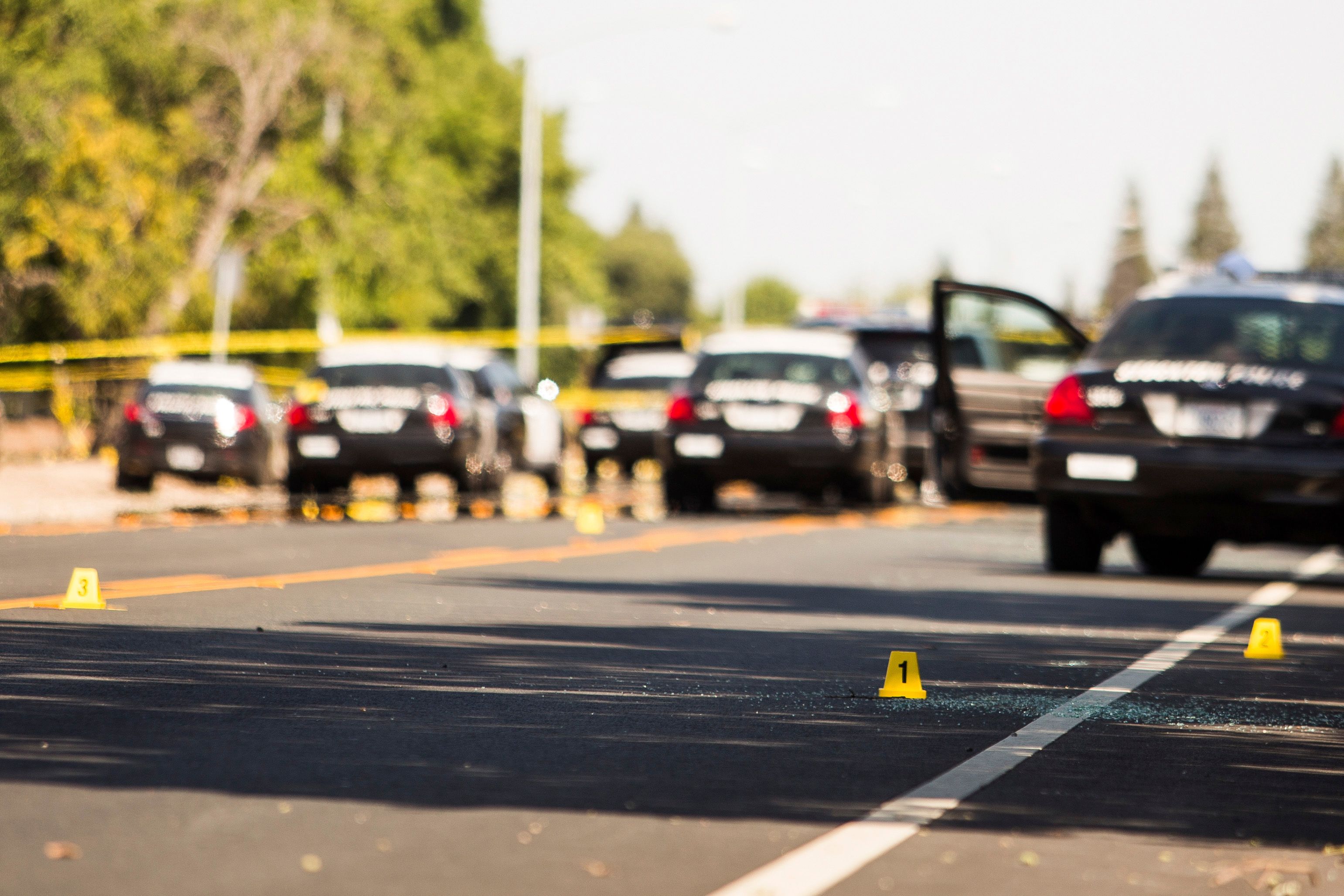 Evidence markers and broken glass mark the scene at the conclusion of a police pursuit in Stockton, California, July 17, 2014. Heavily armed bank robbers who took hostages and engaged police in a running gun battle during a high-speed chase across three Northern California communities were bent on killing officers, a police chief said on Thursday. The incident that began with a robbery at a Bank of the West branch in Stockton on Wednesday afternoon ended with two of the suspects and one of their three female hostages dead, Stockton Police Chief Eric Jones said. REUTERS/Max Whittaker (UNITED STATES - Tags: CRIME LAW)