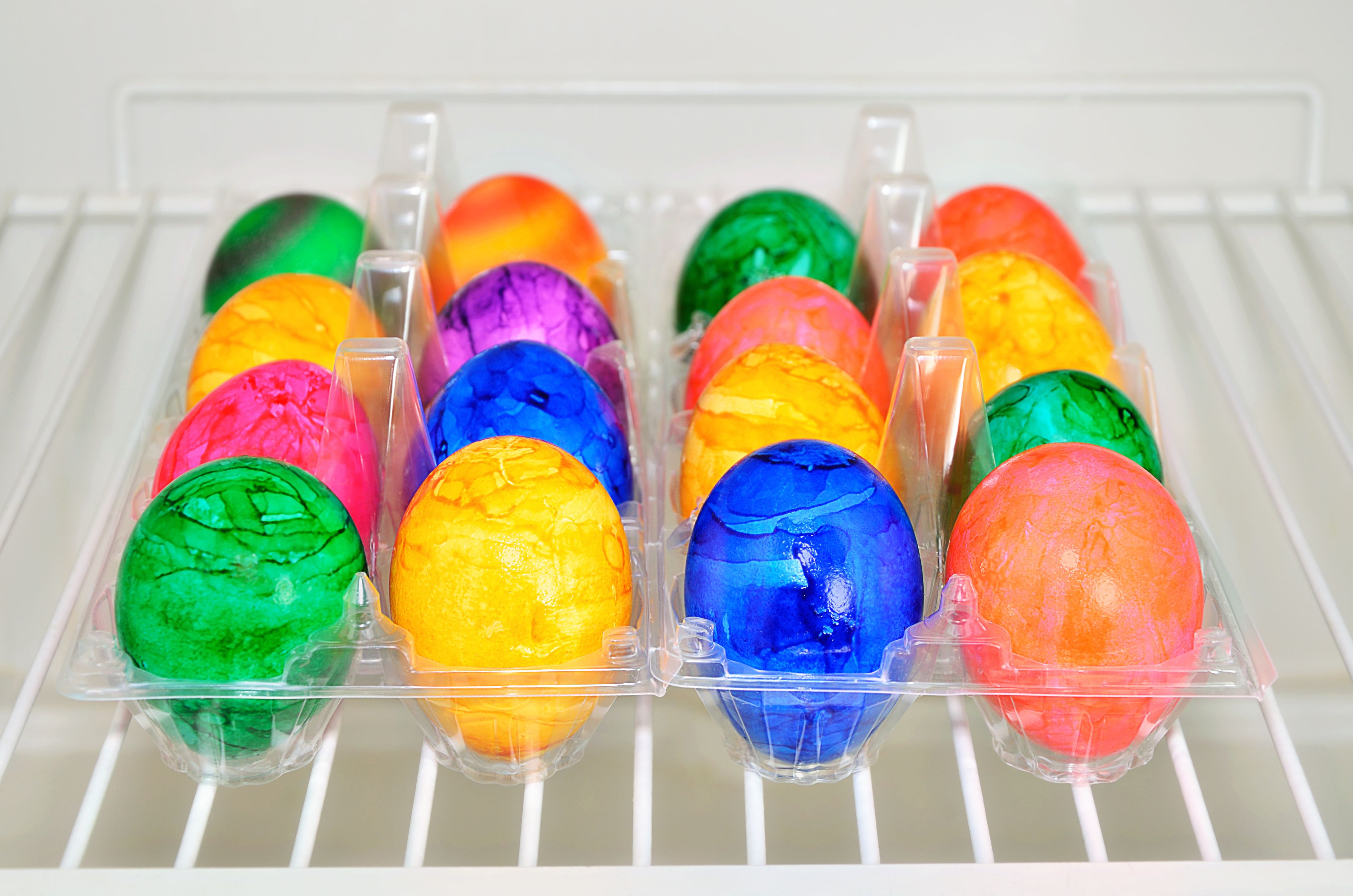 colorful easter eggs in a plastic box, inside a fridge, close up