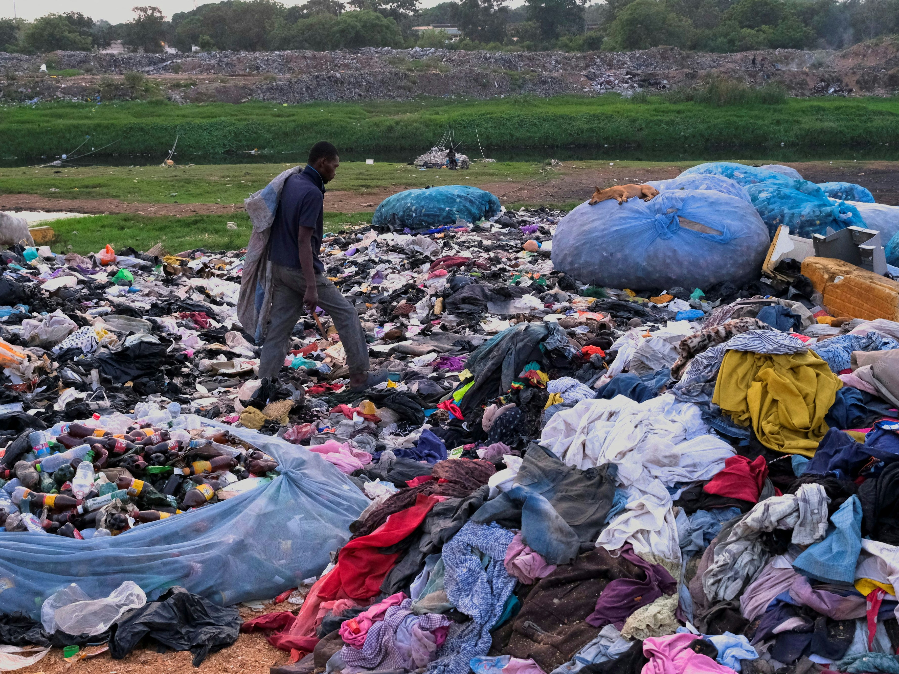 A man scavenges a dumpsite where second-hand clothes are discarded in Accra, Ghana, December 21, 2022. REUTERS/Francis Kokoroko