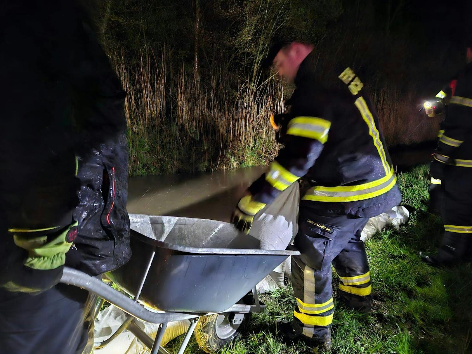 Sandsäcke werden am Ufer angebracht, um das Wasser zurückzuhalten.