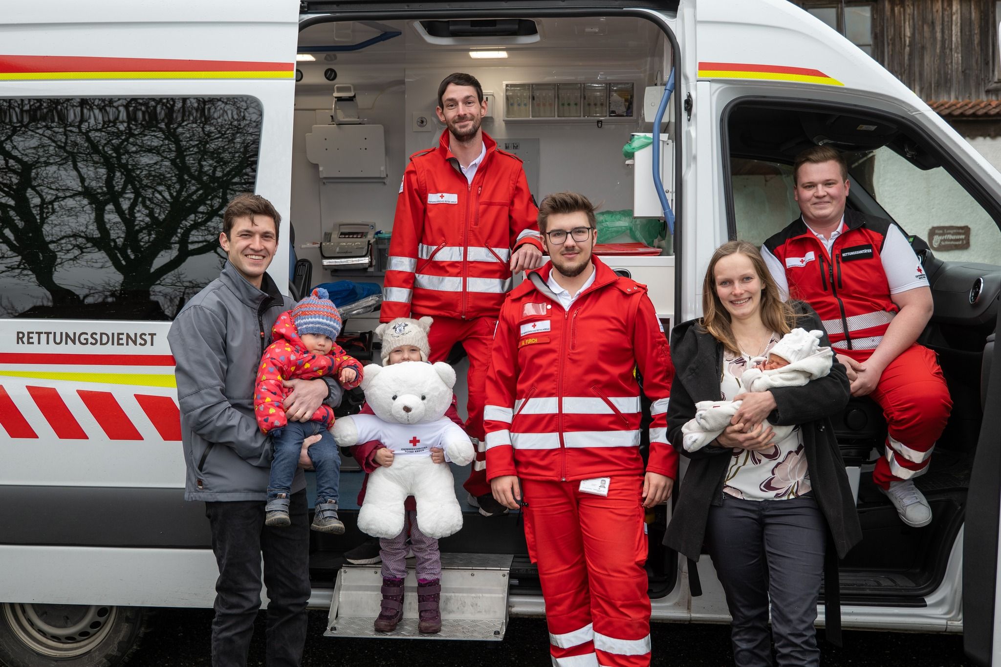 Familie Langwieder mit Rotkreuz-Geburtshelfern (v.l.): Herr Langwieder mit den beiden Töchtern, Rettungssanitäter Hermann Hupf und Michael Furch, Raphaela Langwieder mit Baby Josef und Rotkreuzhelfer Maximilian Gerbl