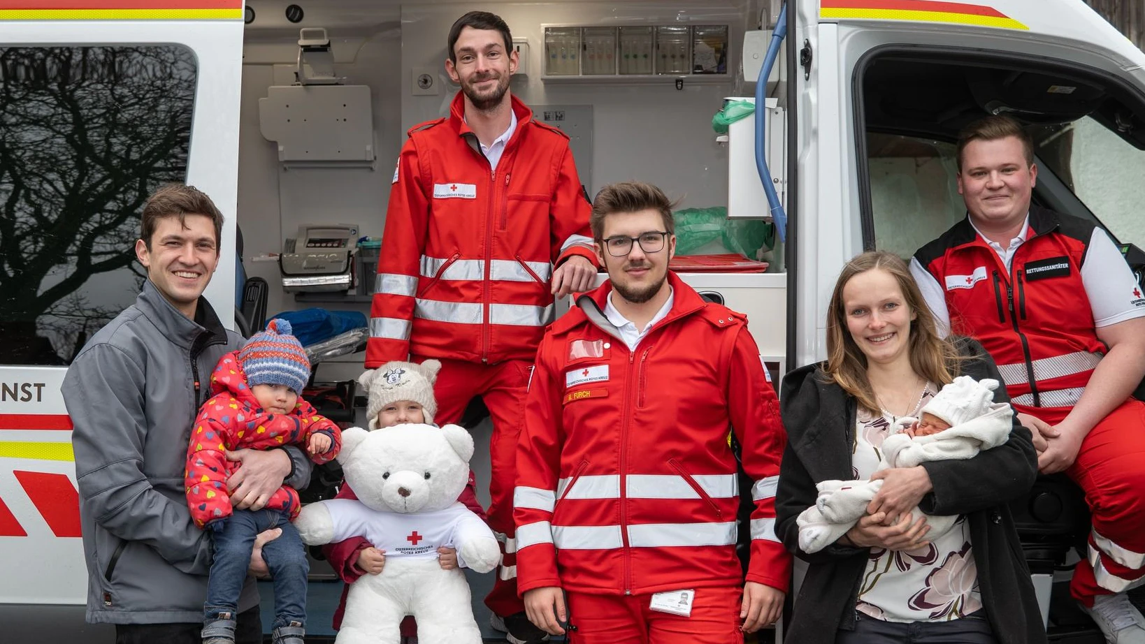 Familie Langwieder mit Rotkreuz-Geburtshelfern (v.l.): Herr Langwieder mit den beiden Töchtern, Rettungssanitäter Hermann Hupf und Michael Furch, Raphaela Langwieder mit Baby Josef und Rotkreuzhelfer Maximilian Gerbl