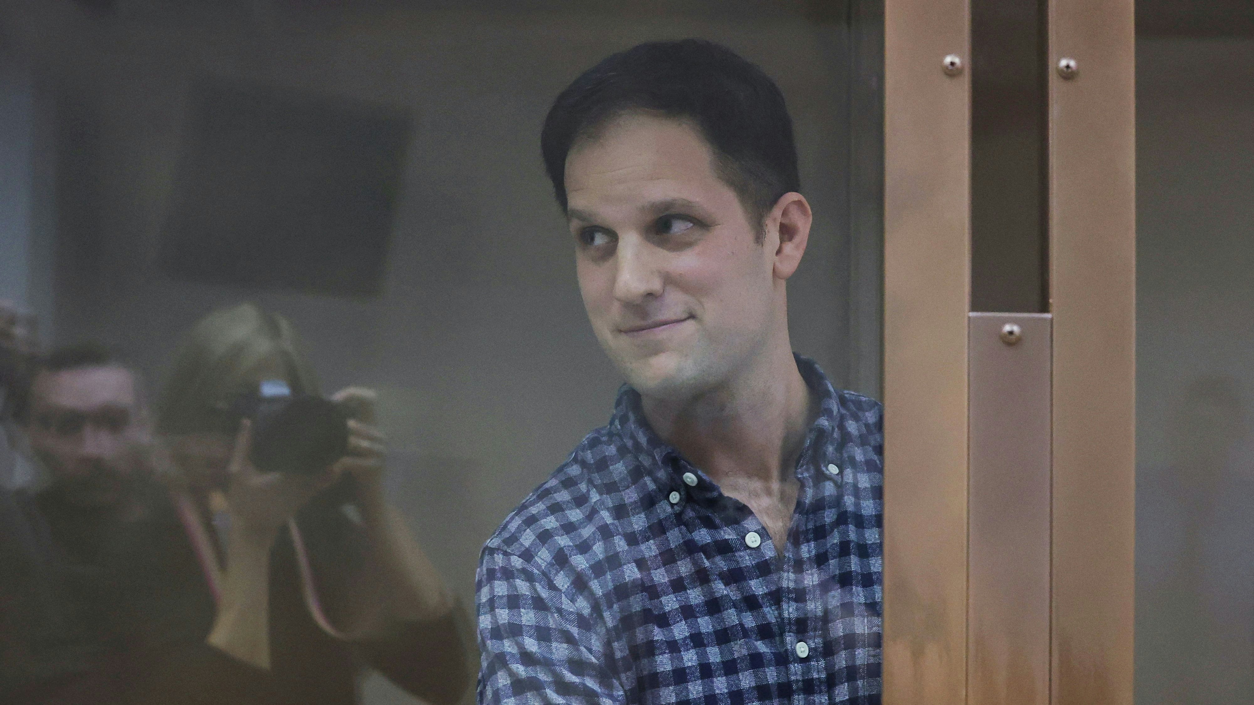Wall Street Journal reporter Evan Gershkovich, who was detained in March while on a reporting trip and charged with espionage, stands behind a glass wall of an enclosure for defendants before a court hearing to consider an appeal against his detention, in Moscow, Russia April 18, 2023. REUTERS/Evgenia Novozhenina