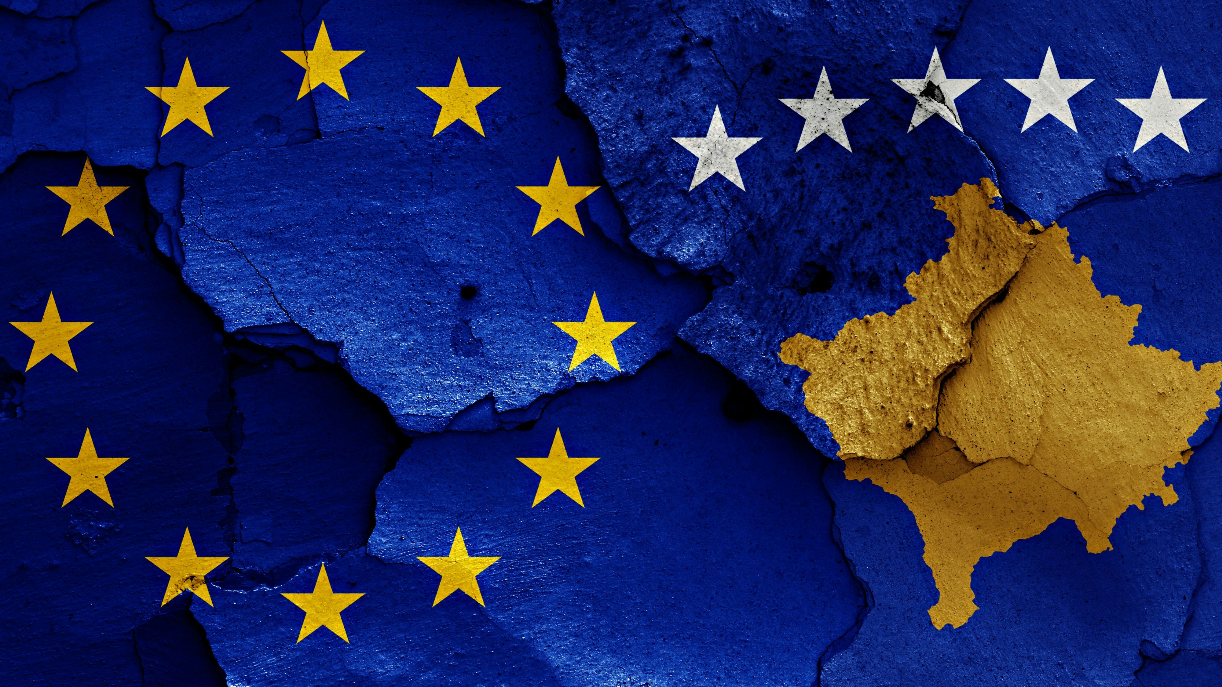 flags of EU and Kosovo painted on cracked wall