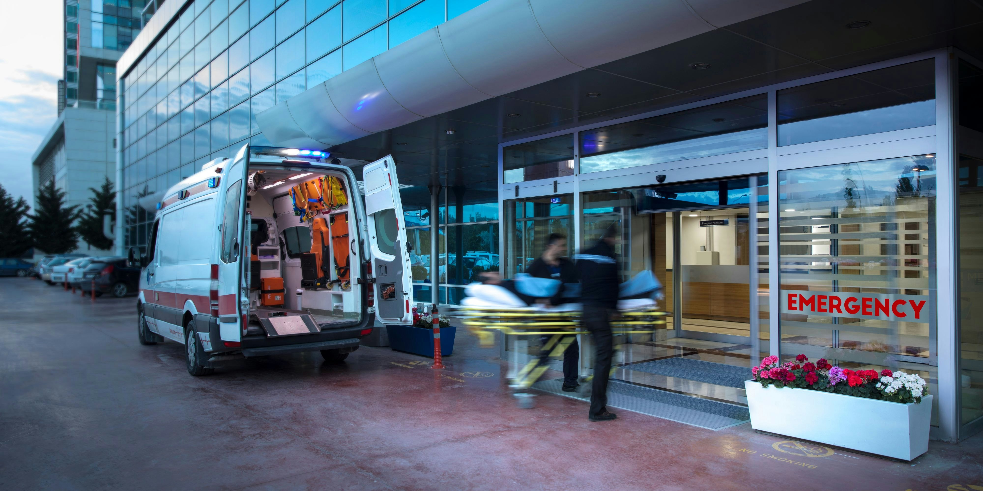 Paramedics taking patient on stretcher from ambulance to hospital