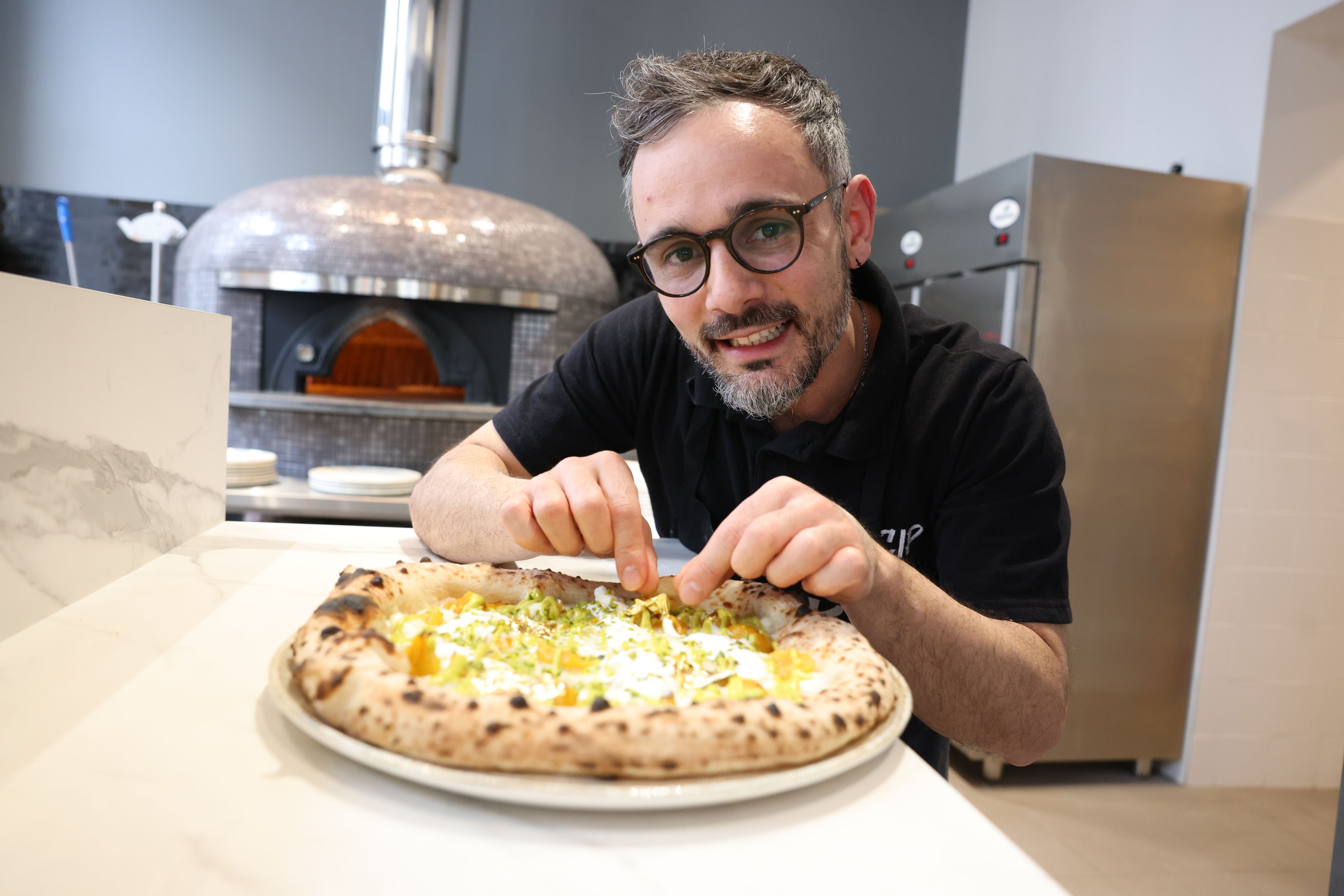 Pizzabäcker Fabio Saccoccio mit seiner Sunset Pizza mit Blattgold auf 72 Stunden lang fermentiertem Teig.