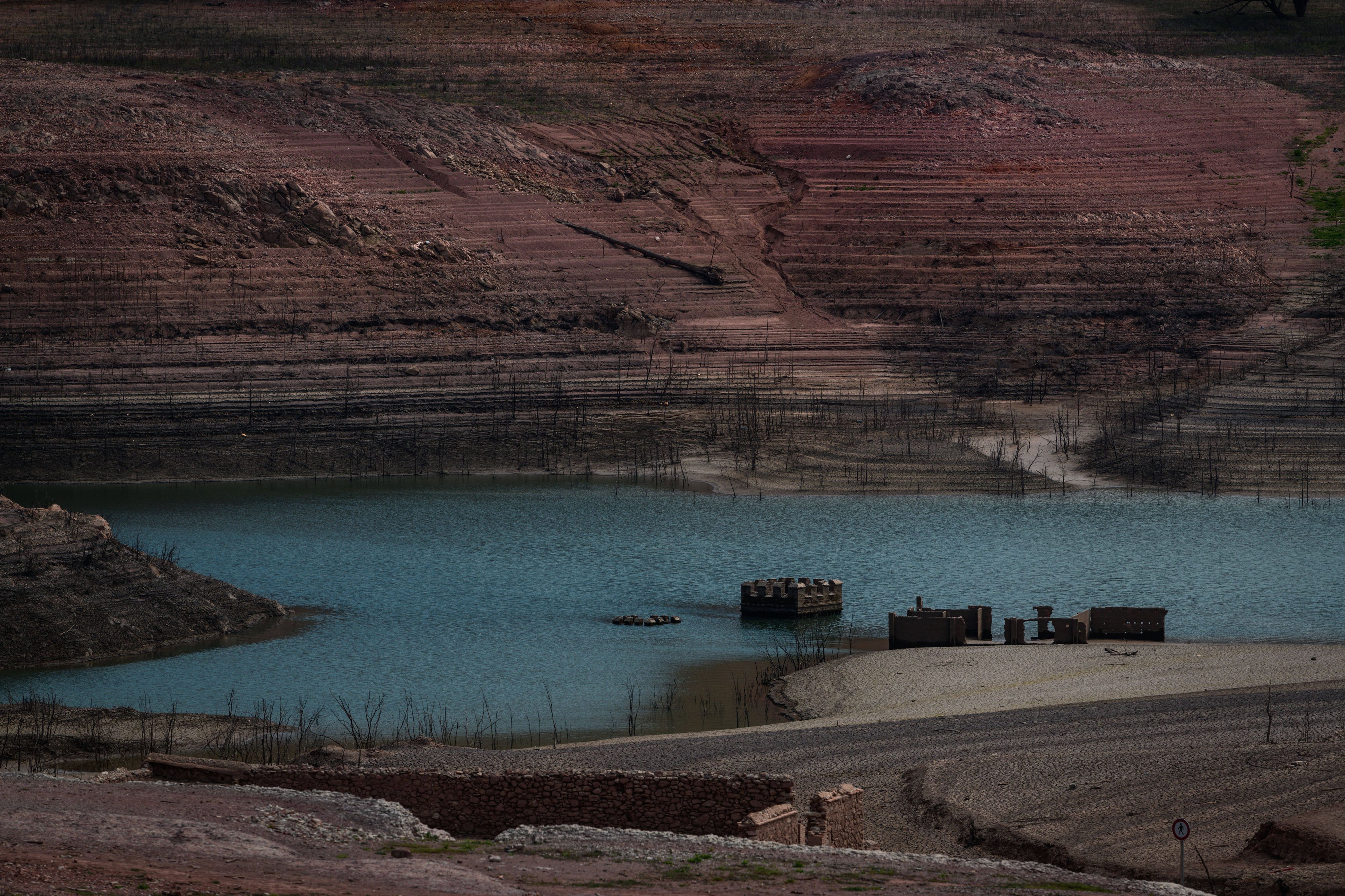 Die Ruinen des alten Dorfes ragen ebenfalls wieder aus dem stetig sinkenden Wasser.