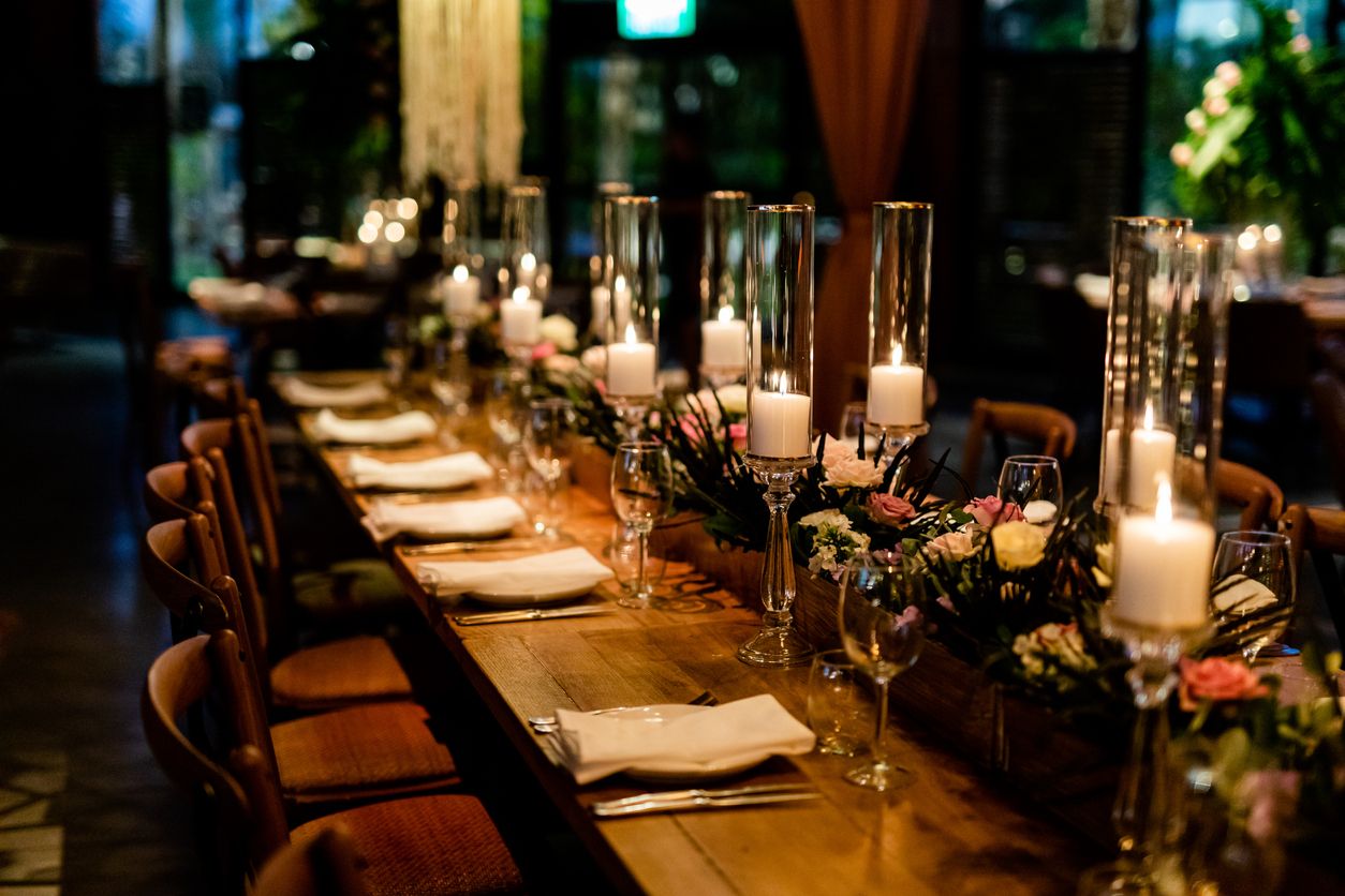Luxury table settings for fine dining with and glassware, pouring wine to glass. Beautiful blurred background. Preparation for holiday wedding. Fancy luxury restaurant.