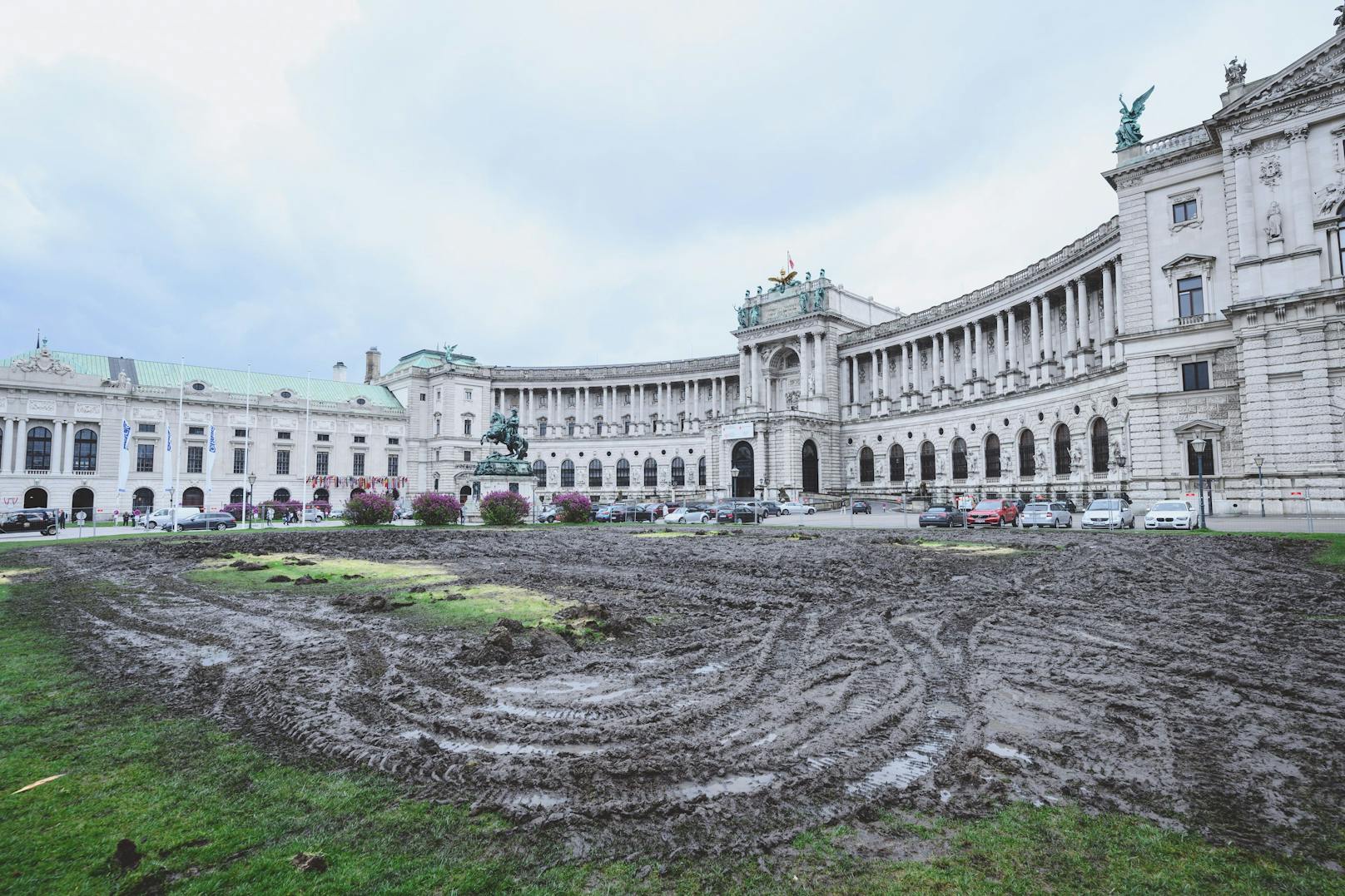 Schwere Baumaschinen haben den Heldenplatz-Rasen vor der Hofburg nach den Regenfällen vom 19. April 2023 zerstört.