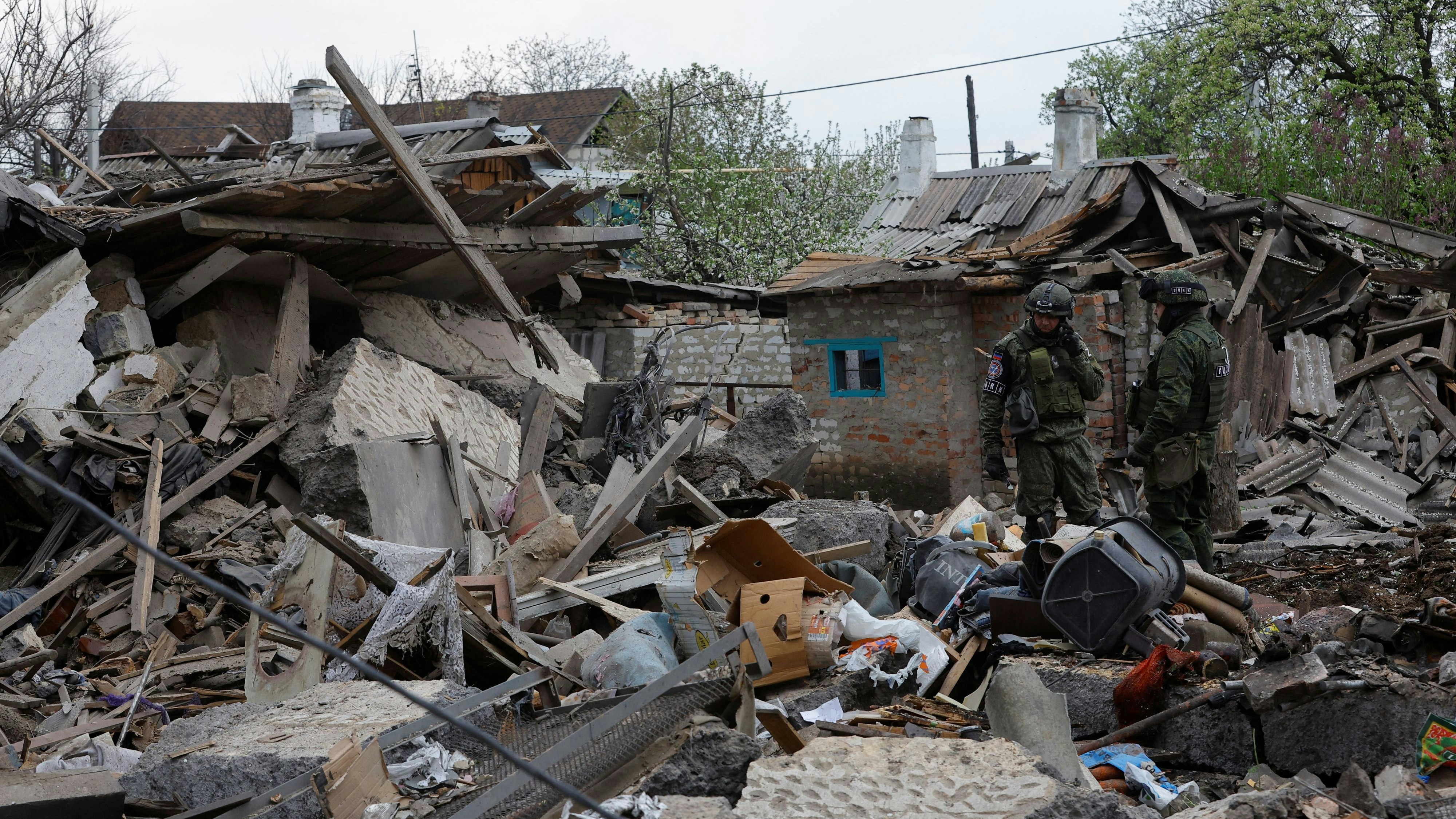 Investigators are seen amid debris of buildings destroyed by shelling in the course of Russia-Ukraine conflict in Donetsk, Russian-controlled Ukraine, April 29, 2023. REUTERS/Alexander Ermochenko