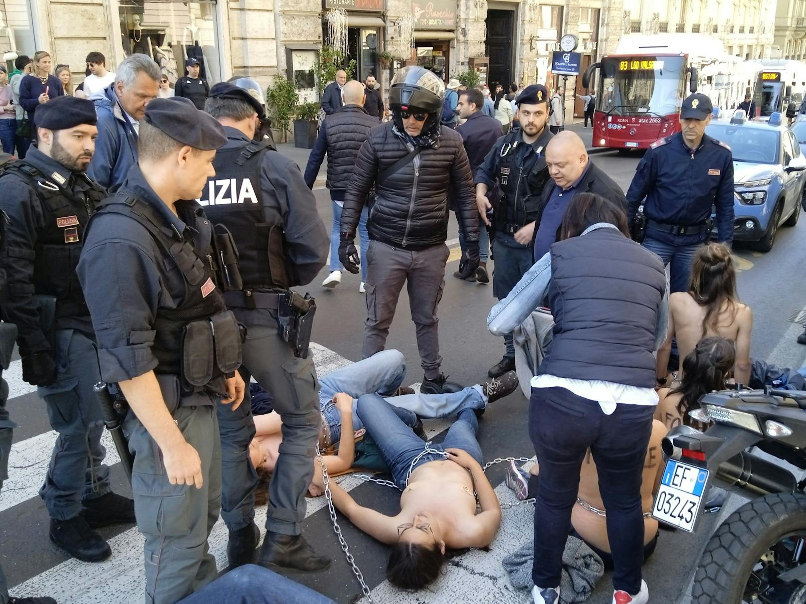 Bilder, die verstören: Aktivisten der "Letzten Generation" (''Ultima Generazione'') umringt von Polizisten, während einer Demonstration in Rom.