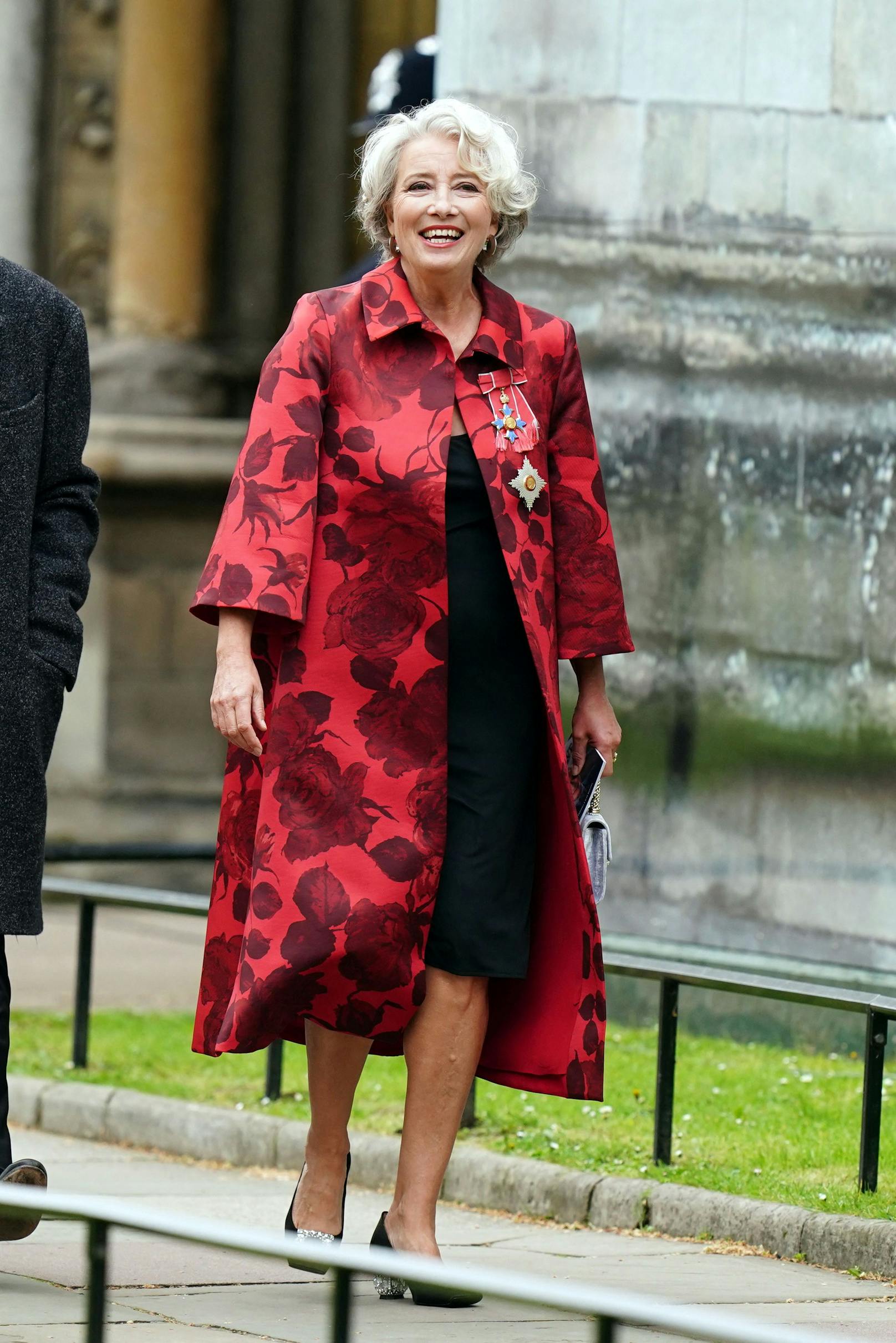 Schauspielerin Dame Emma Thompson wählt für die Krönung ein schwarzes knielanges Kleid. Darüber trug die 64-Jährige einen roten Mantel mit Blumenmuster.