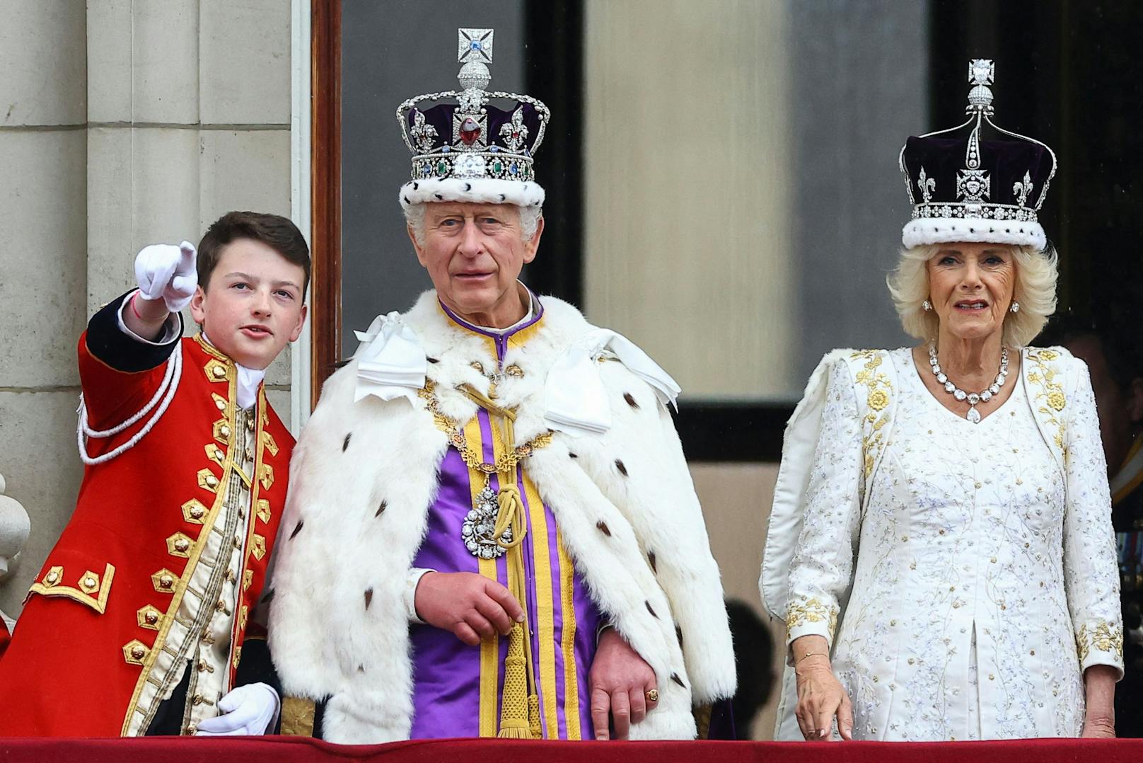 Der frisch gekrönte König Charles III. und Ehefrau, Queen Camilla, die sich am Balkon des Buckingham Palace der begeisterten Menschenmenge zeigten. Sein Page an der linken Seite, Ralph Tollemache.