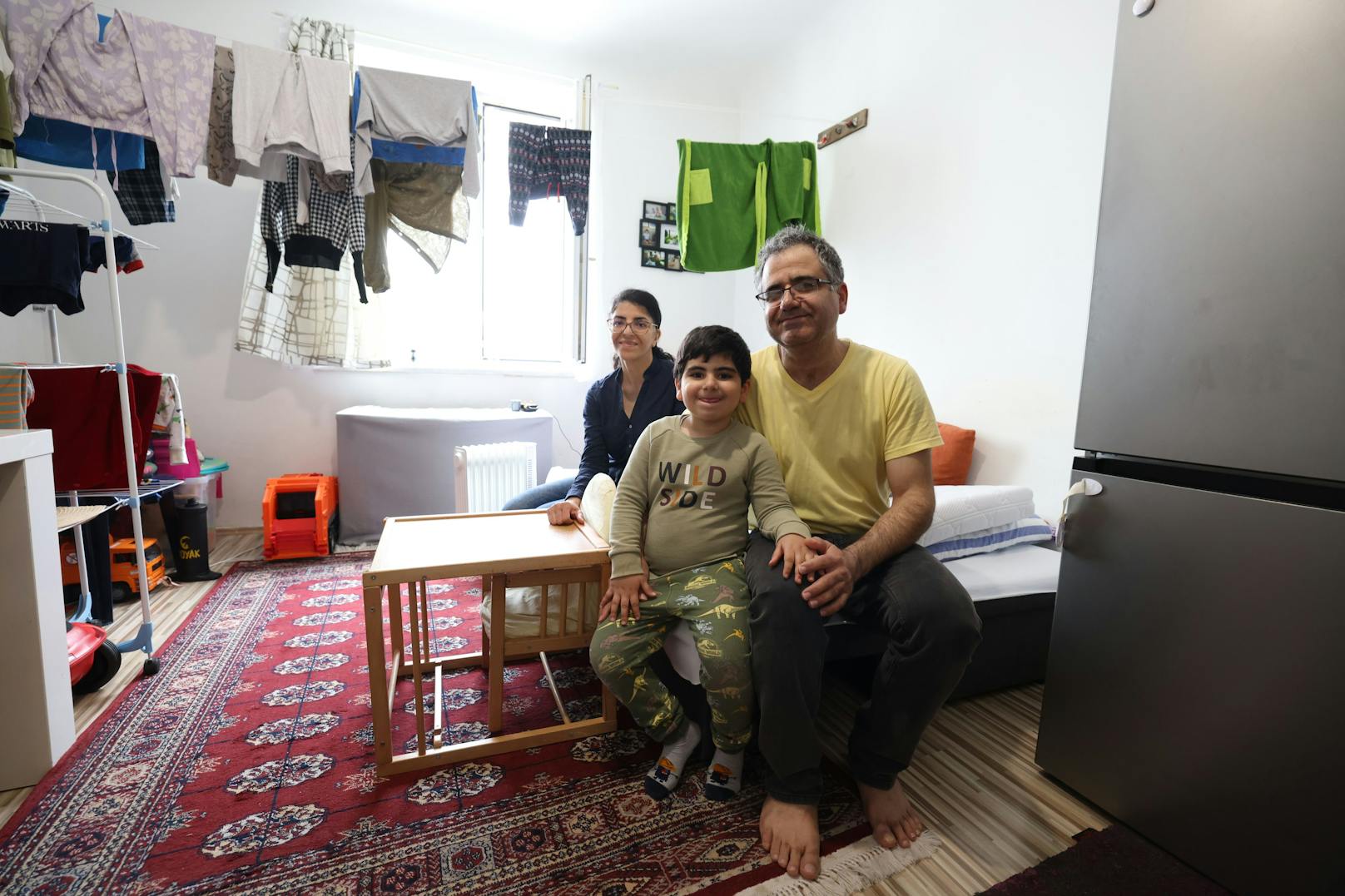 Familie trocknet Wäsche im Wohnzimmer.