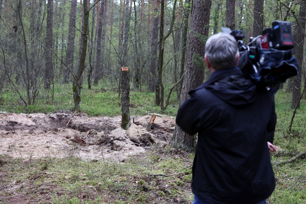 Ein Kamerateam eines polnischen Senders an der Absturzsstelle der Rakete.