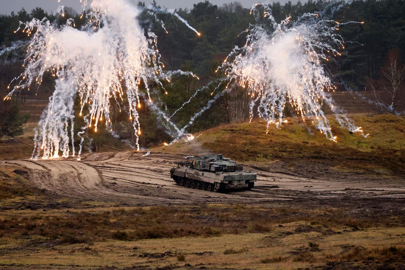 Ein deutscher Leopard 2-A6 Kampfpanzer im Gelände demonstriert seinen Nebelwerfer. Aufgenommen im Februar 2023.