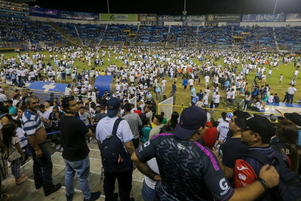 Fans flüchten aus Angst zertrampelt zu werden auf das Feld.