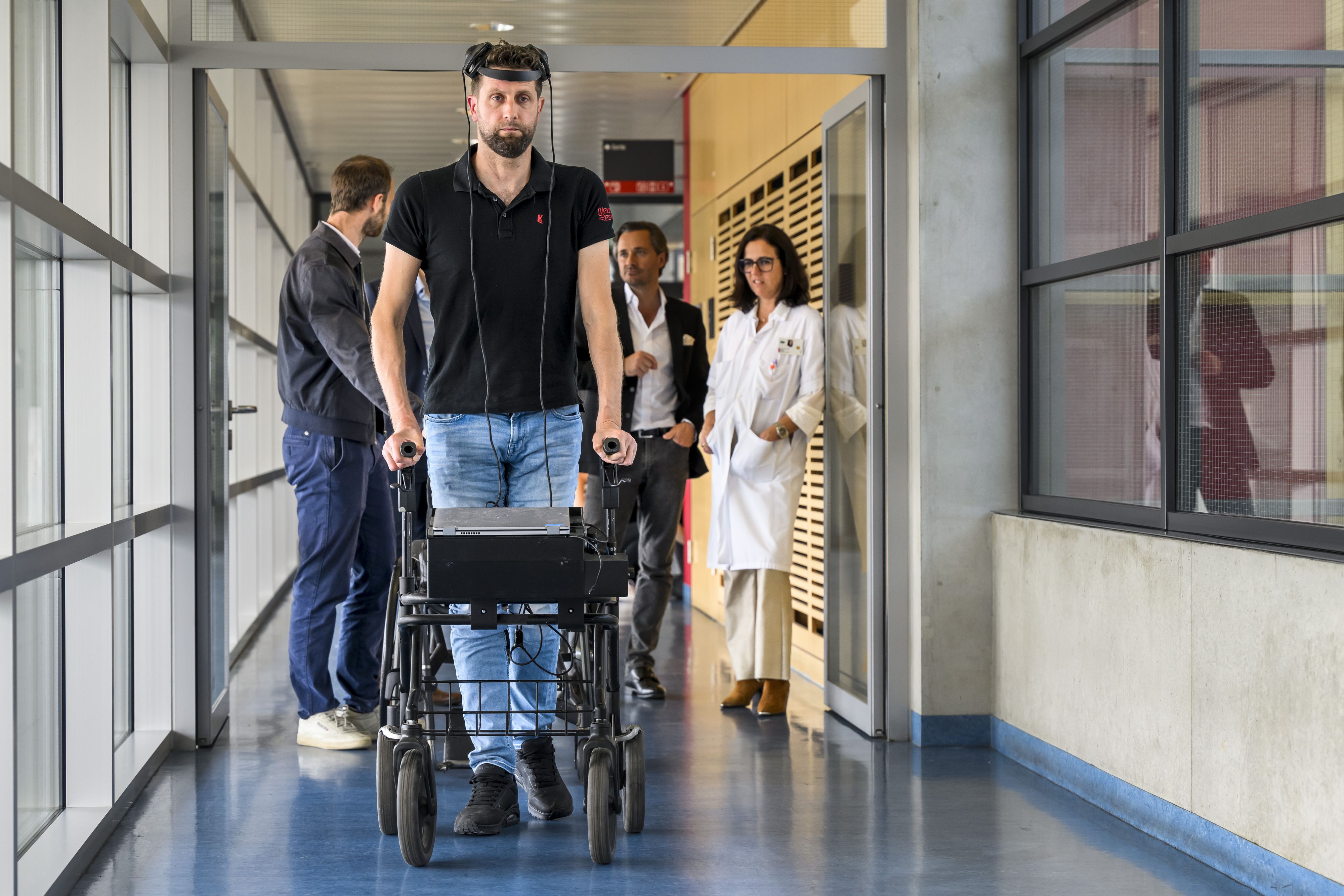 Download von www.picturedesk.com am 25.05.2023 (15:56).  EMBARGO UNTIL MAY 24, 17:00 CET - Dutch paraplegic patient Gert-Jan, center, walks thanks the Brain Computer Interface (BCI) enables thought-controlled walking after spinal cord injury, during a press conference in Lausanne, Switzerland, Tuesday, May 23, 2023. Neuroscientists from EPFL, Swiss Federal Institute of Technology Lausanne, CHUV/UNIL, Lausanne University Hospital and CEA, University Grenoble Alpes Hospital CHUGA, University Grenoble Alpes UGA, will publish in the prestigious scientific journals Nature that they have re-established the communication between the brain and spinal cord with a wireless digital bridge, allowing a paralyzed person to walk again naturally. (KEYSTONE/Jean-Christophe Bott) - 20230524_PD7344 - Rechteinfo: Rights Managed (RM)