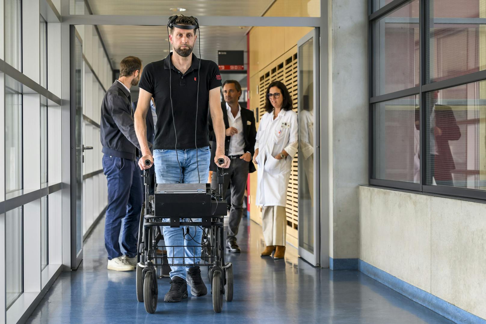 Der querschnittsgelähmte niederländische Patient Gert-Jan (Mitte) geht dank des Brain Computer Interface (BCI), das gedankengesteuertes Gehen nach einer Rückenmarksverletzung ermöglicht.