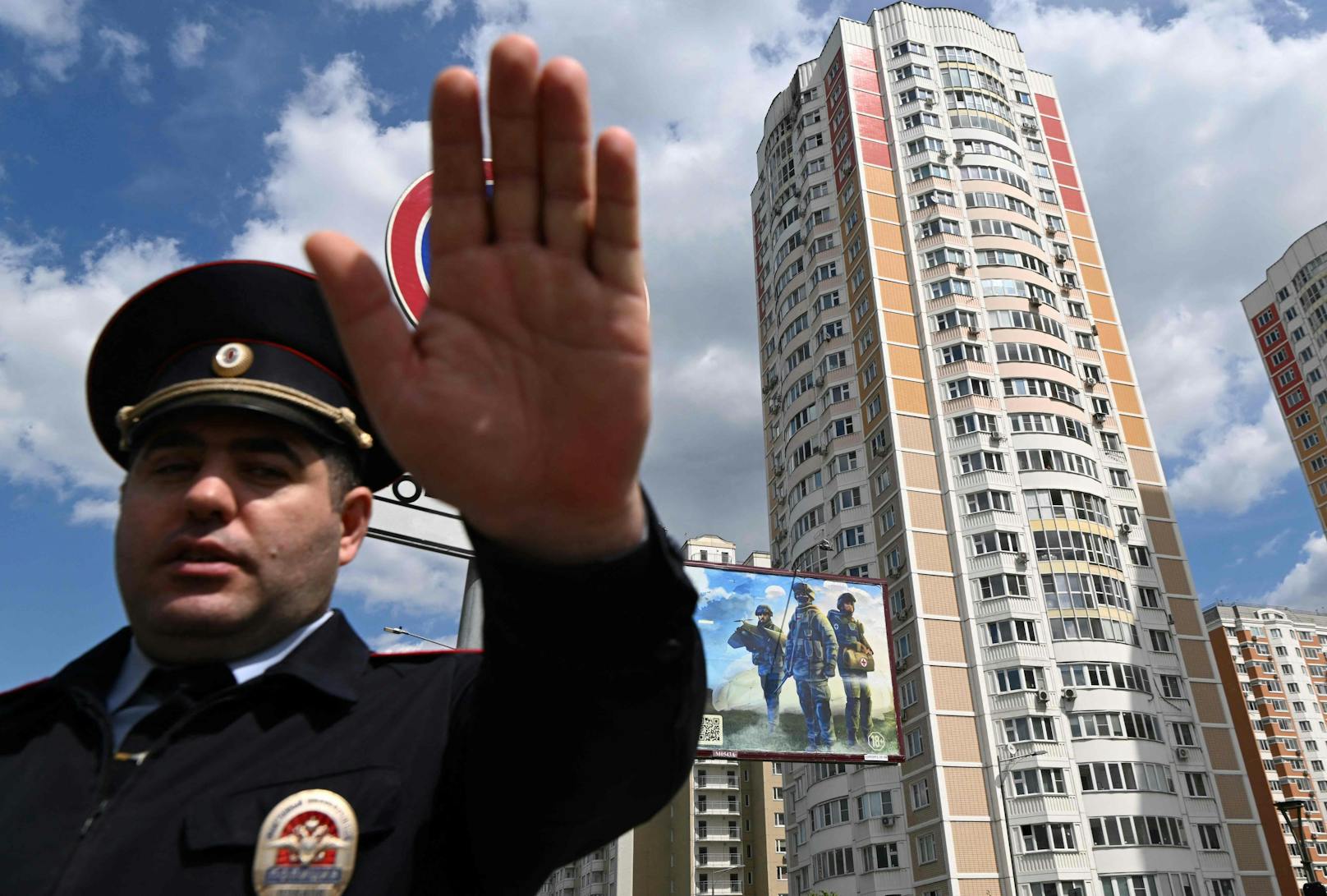 Ein Polizist in Moskau sichert einen Bereich vor einem beschädigten mehrstöckigen Wohnhaus.