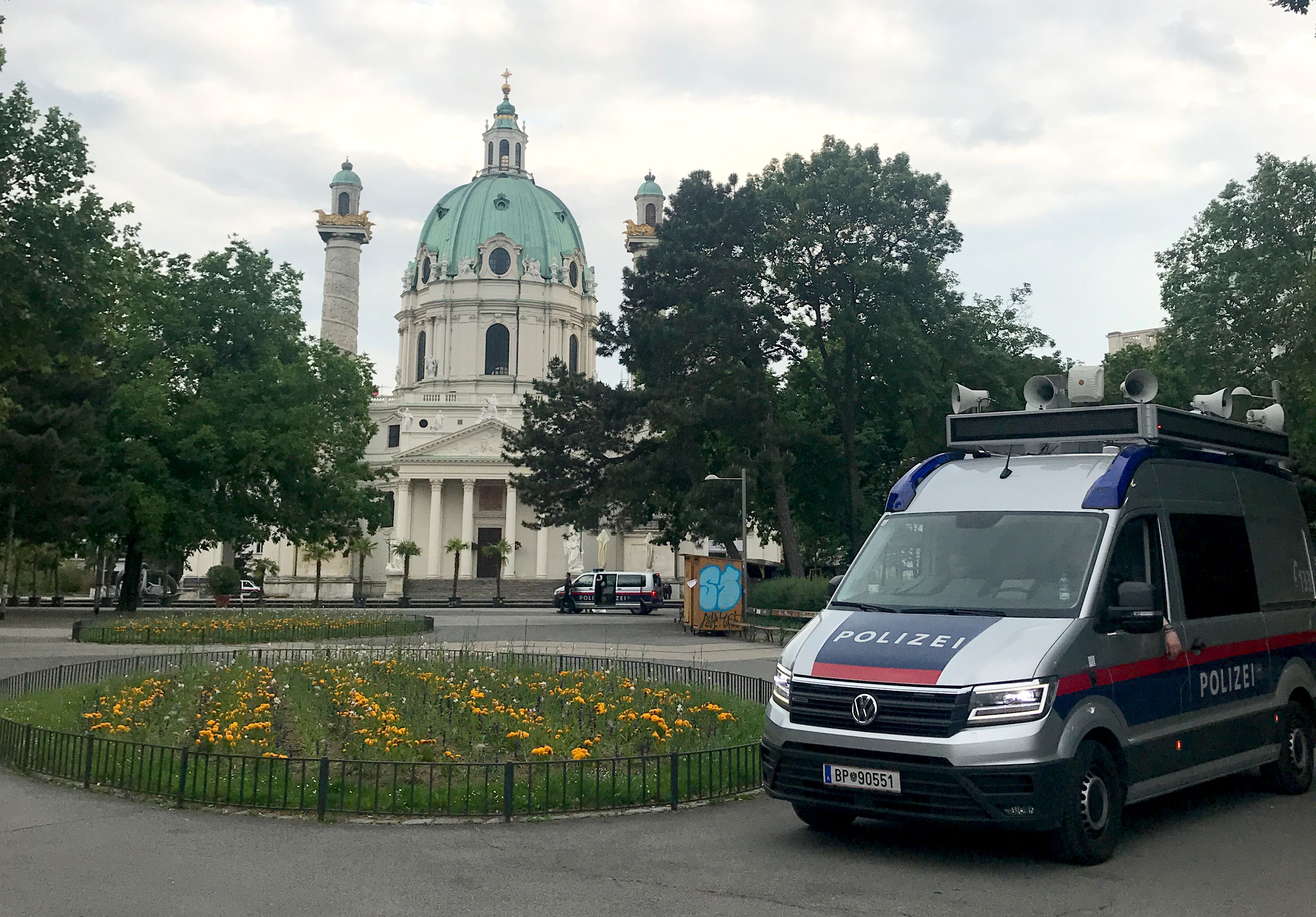 Polizeifahrzeuge im Resselpark vor der Karlskirche in Wien.