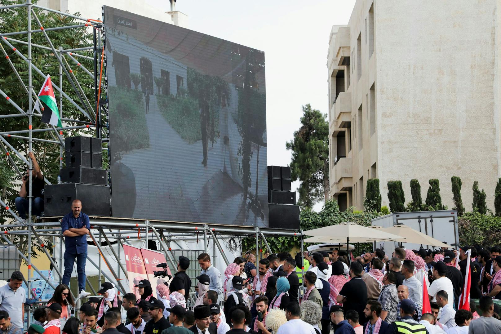 Ein riesiger Bildschirm zeigt die Ankunft von Rajwa Al Saif am Tag ihrer Hochzeit mit Kronprinz Hussein in Amman, Jordanien.