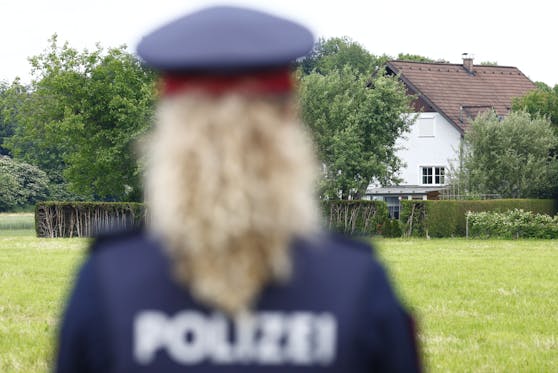 Einsatzkräfte der Polizei sichern den Tatort, ein Wohnhaus in Fluttendorf nahe Graz.