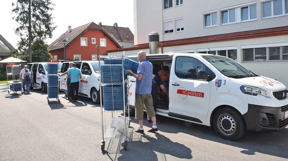 Beladung der Essen auf Rädern-Busse beim Seniorenwohnheim Stadtwald.