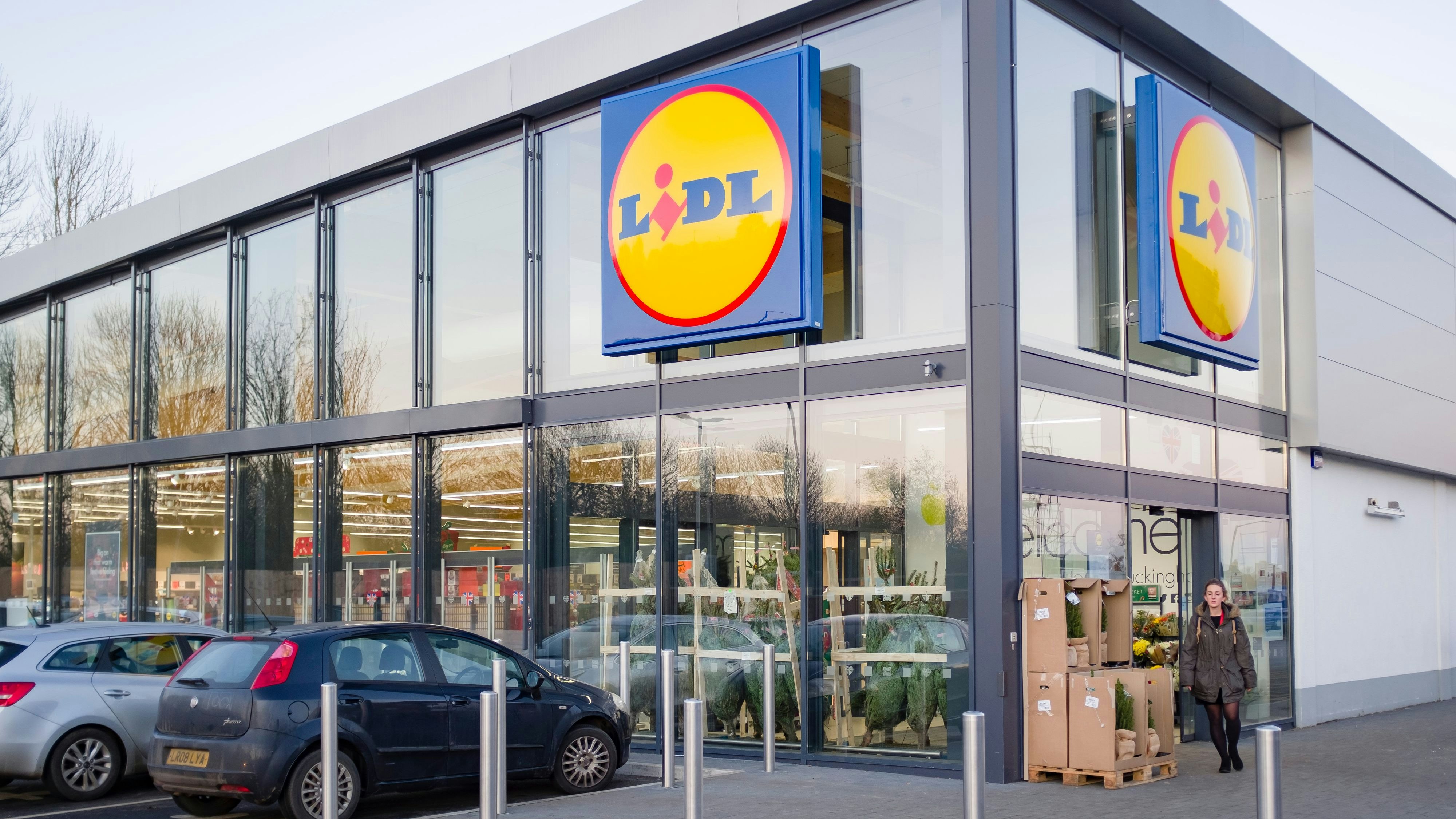 BUCKINGHAM, UK - December 04, 2019. Lidl supermarket store exterior, with woman shopper outside the entrance.