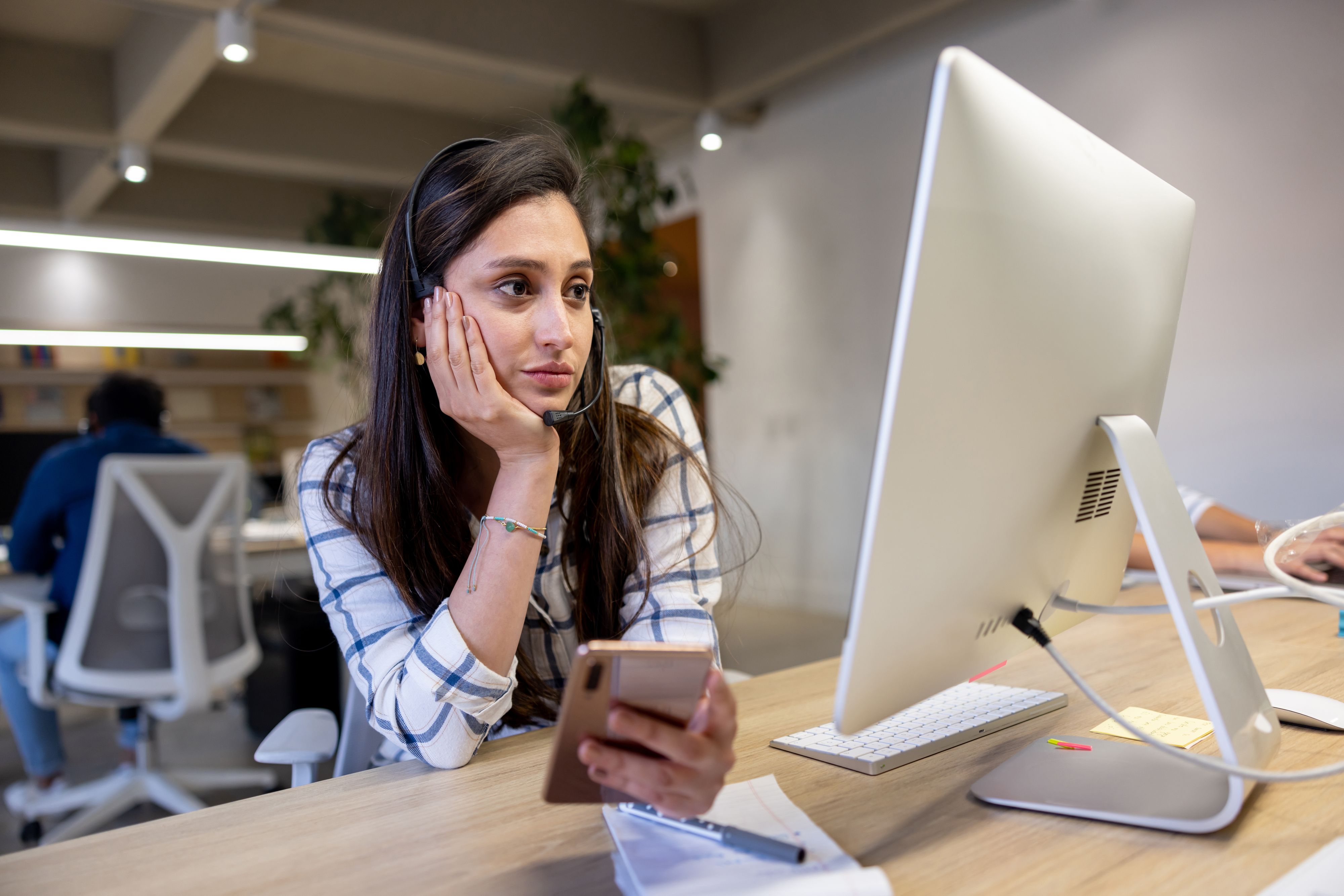 Sekretärin vor dem Computer mit Handy