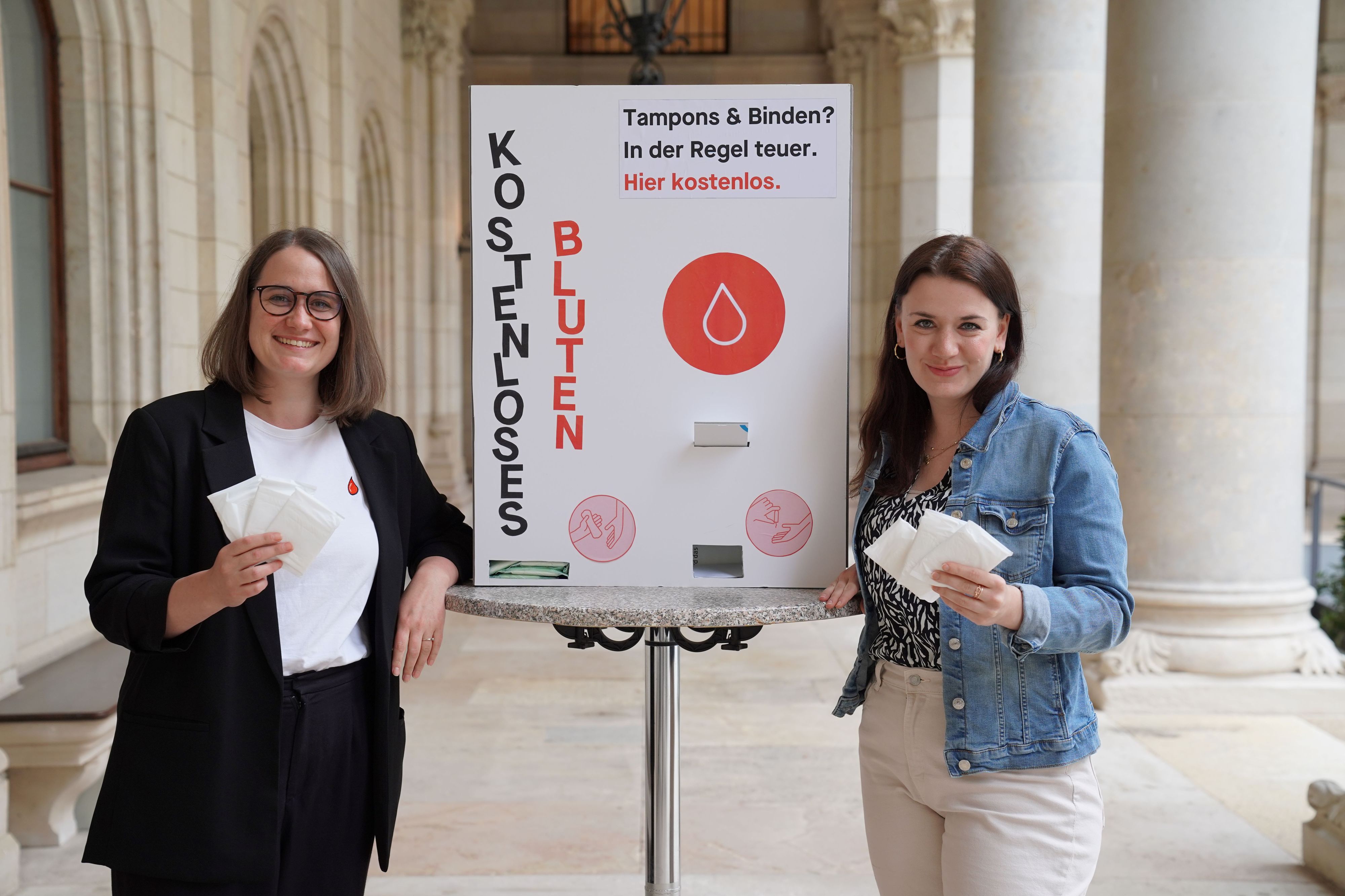 Dolores Bakos (NEOS) und Marina Hanke (SPÖ) präsentieren das Pilotprojekt "Kostenloses Bluten" an neuen Wiener Schulen. 