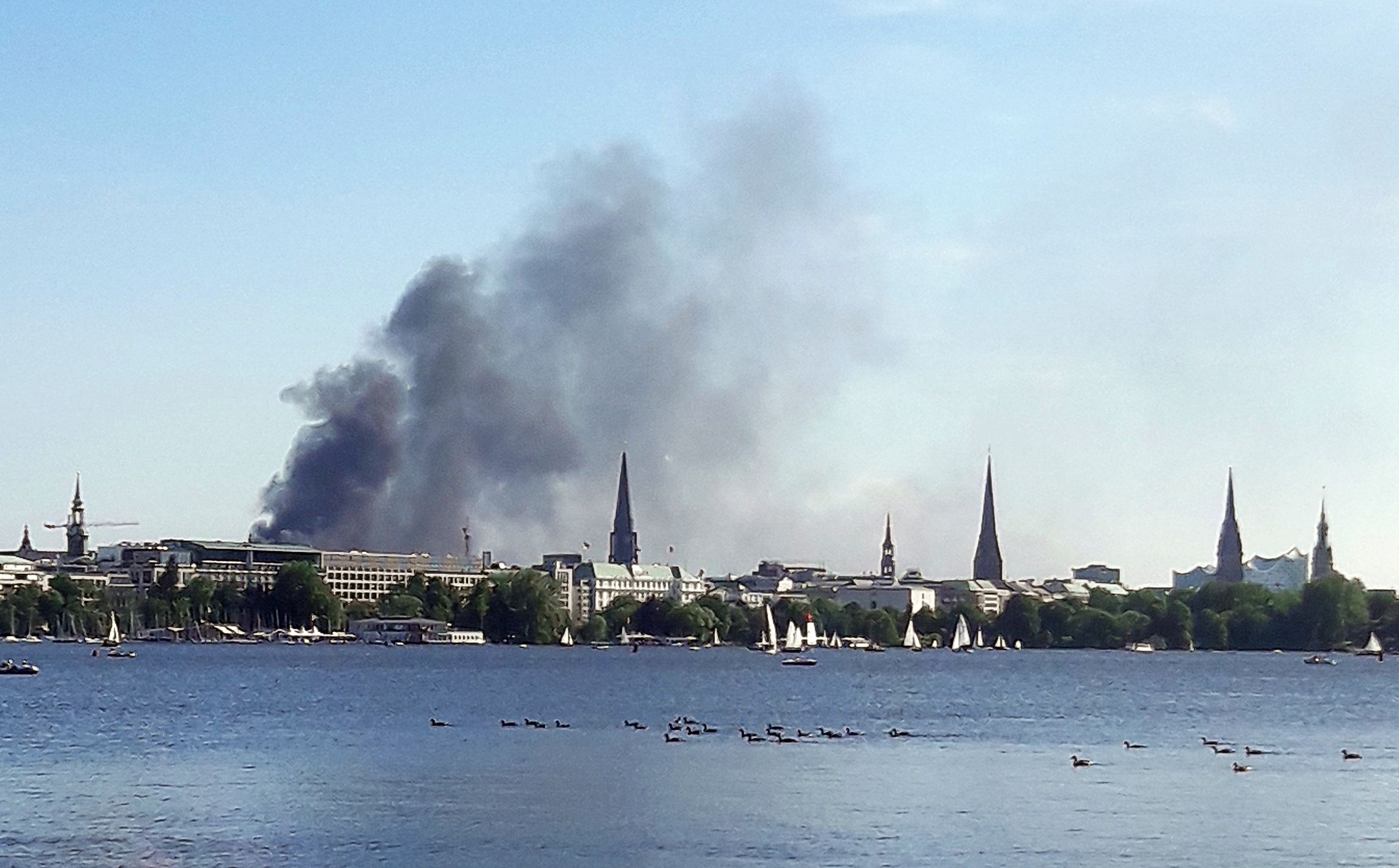 Download von www.picturedesk.com am 09.06.2023 (18:48).  09 June 2023, Hamburg: A cloud of smoke can be seen over the Alster in Hamburg. Several explosions occurred on a ten-story building in Hamburg's HafenCity on Friday afternoon. Photo: Désirée Ballhausen/-/dpa - 20230609_PD6580 - Rechteinfo: Rights Managed (RM)