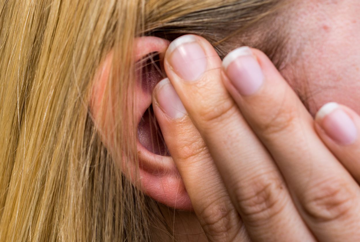 Woman lays finger on the ear