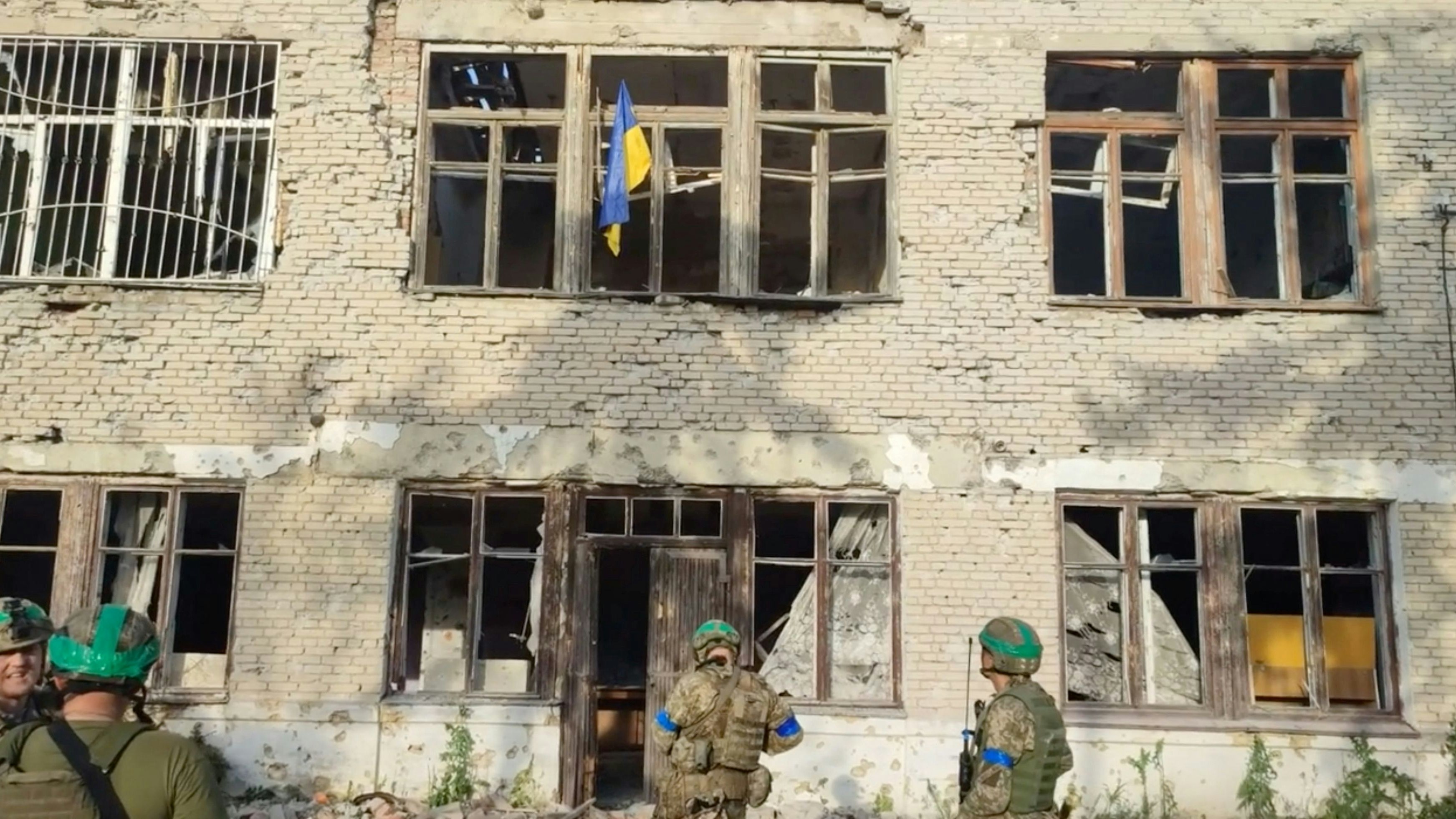 Ukrainian soldiers stand in front of a building with a Ukrainian flag on it, during an operation that claims to liberate the first village amid a counter-offensive, in a location given as Blahodatne, Donetsk Region, Ukraine, in this screengrab taken from a handout video released on June 11, 2023. 68th Separate Hunting Brigade 'Oleksy Dovbusha'/Handout via REUTERS    THIS IMAGE HAS BEEN SUPPLIED BY A THIRD PARTY. NO RESALES. NO ARCHIVES. MANDATORY CREDIT. REUTERS WAS NOT ABLE TO INDEPENDENTLY VERIFY THE LOCATION OF THE VIDEO AND THE DATE IT WAS FILMED.
