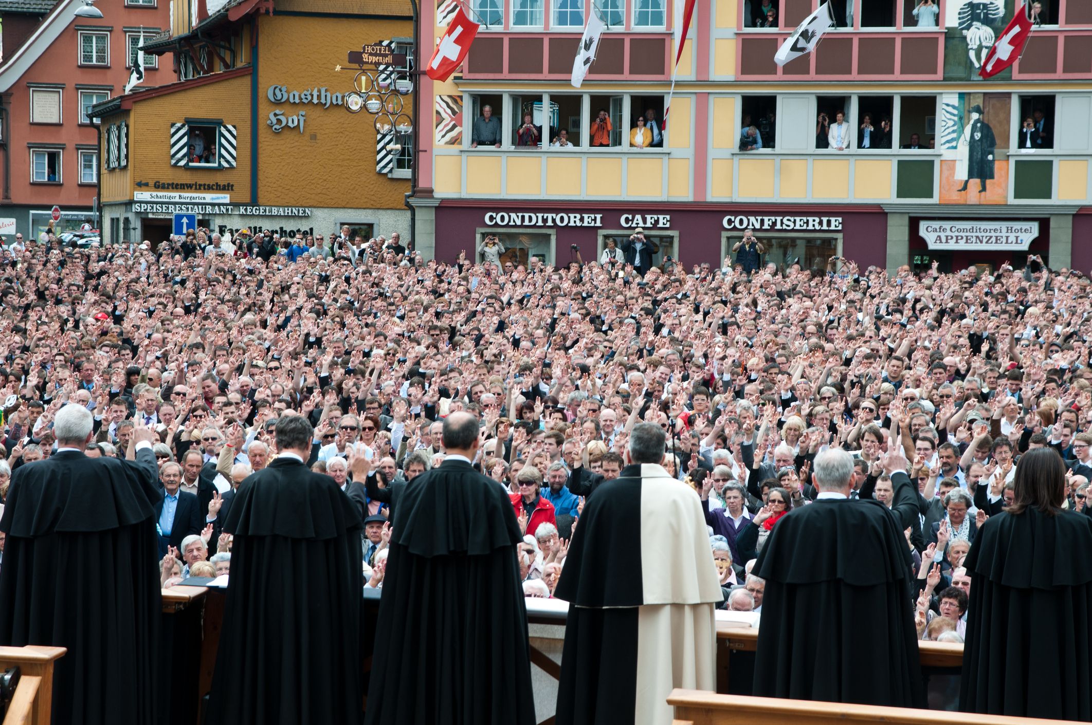 Appenzell, Switzerland - May 1, 2011: The people of Appenzell are voting at the Landsgemeide. In the foreground the governement in old dresses. The Landsgemeinde is held in the open air, in which every male and female citizen over eighteen years of age have to appear personally to vote and elect with raising the right hand to cast one\'s vote. The first historically documented assembly in Switzerland took place in 1294