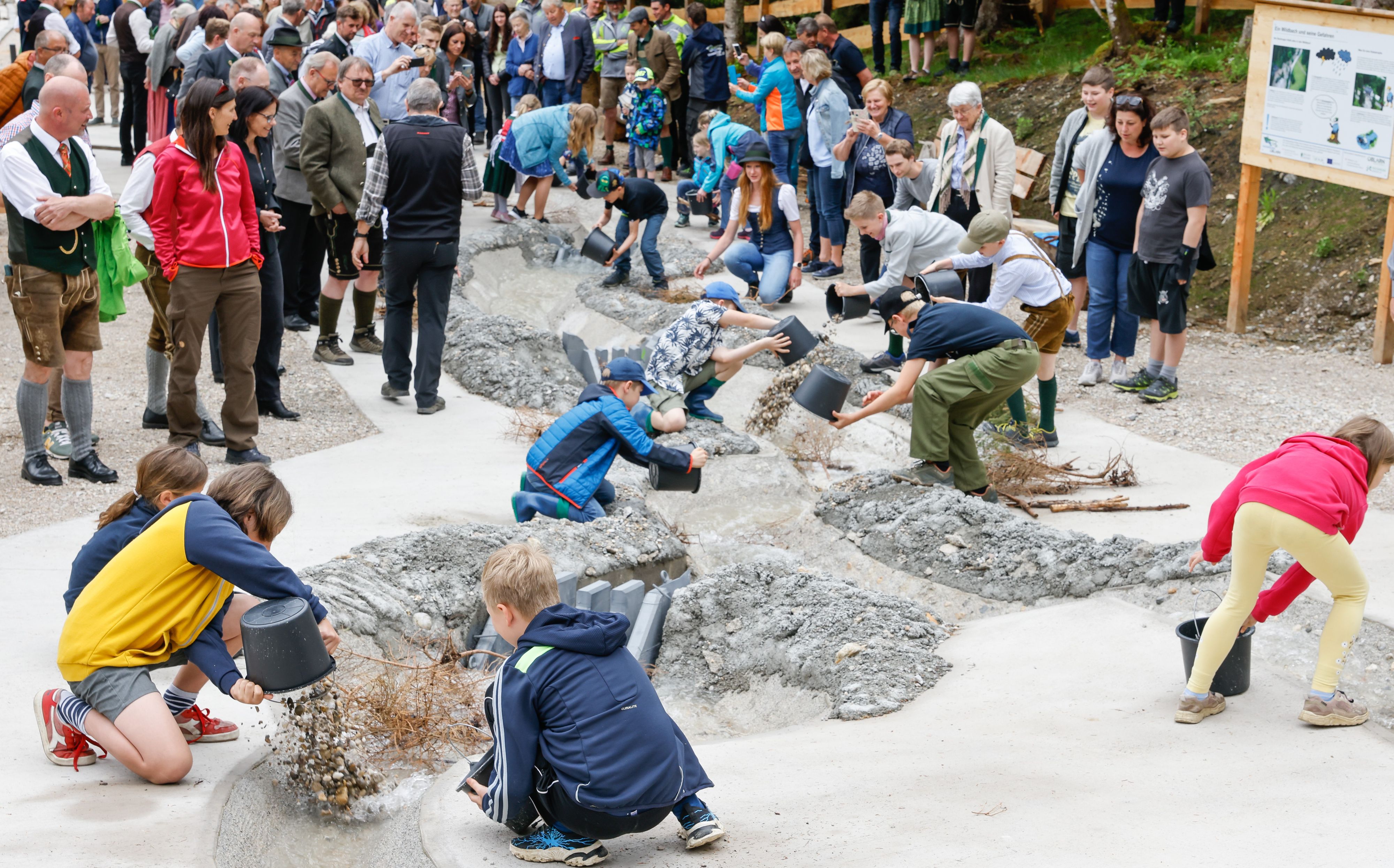 Offizielle feierliche Eröffnung Wassererlebnis Öblarn am Modellstandort im Walchental - im Bild Besucher und Kinder, die im Demonstrationsmodell Verklausungen herbeiführen. 