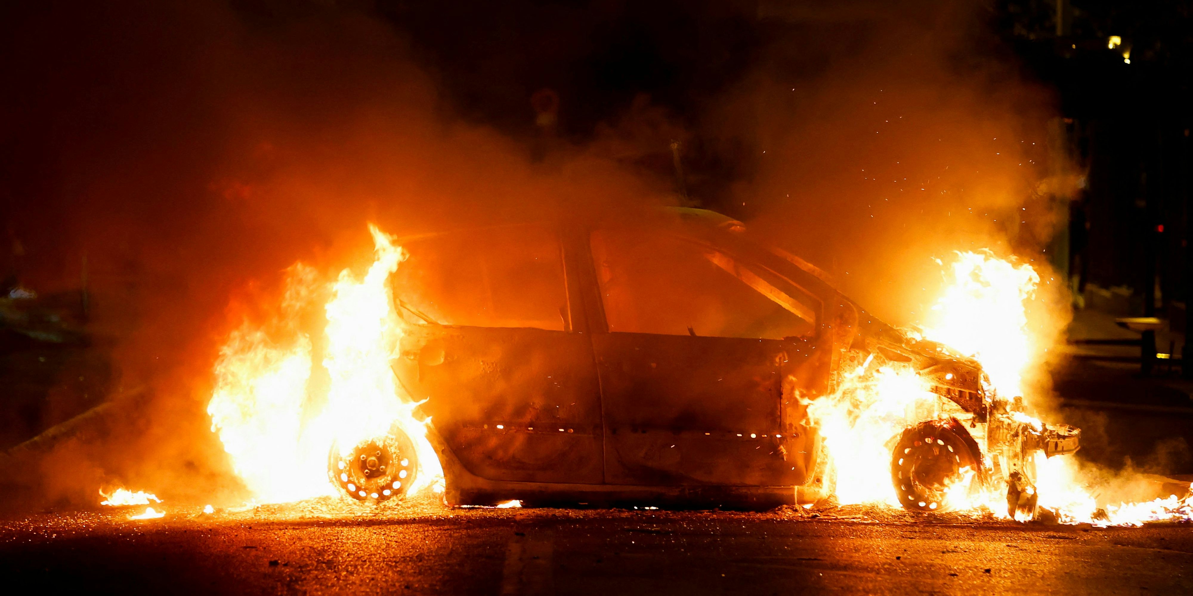 A vehicle burns during clashes between protesters and police, following the death of Nahel, a 17-year-old teenager killed by a French police officer during a traffic stop, in Nanterre, Paris suburb, France, June 29, 2023. REUTERS/Gonzalo Fuentes