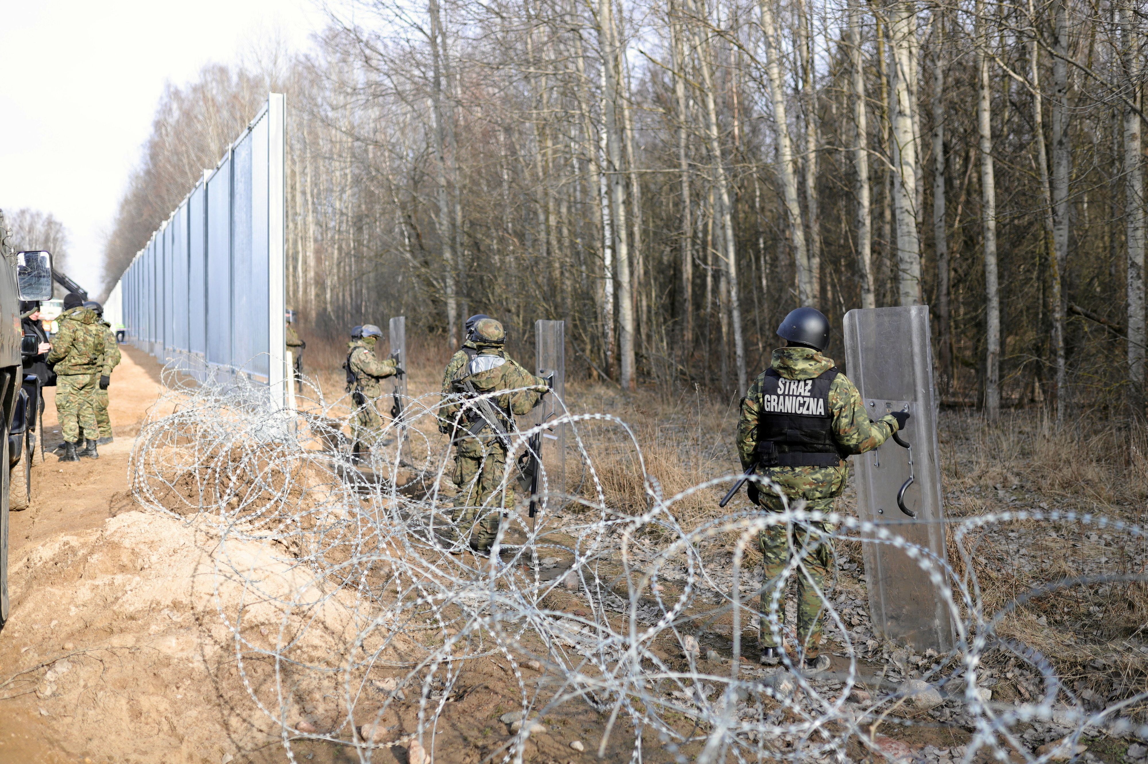 Members of the Polish Border Guard and Polish soldiers, stand guard at the construction site of a barrier at the border between Poland and Belarus in Tolcze near Kuznica, Poland, February 16, 2022. Grzegorz DabrowskiAgencja Wyborcza.pl via REUTERS ATTENTION EDITORS - THIS IMAGE WAS PROVIDED BY A THIRD PARTY. POLAND OUT. NO COMMERCIAL OR EDITORIAL SALES IN POLAND.