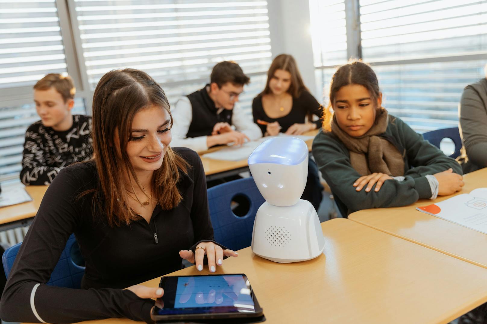 Der Roboter wird im Klassenzimmer am Tisch platziert, während sich der Teilnehmer von zu Hause oder dem Krankenbett aus mit dem Tablet oder Smartphone verbindet.