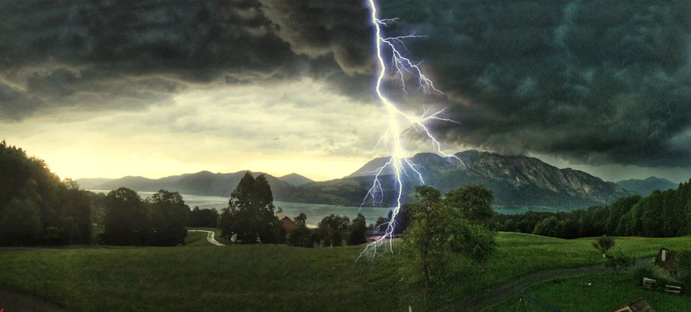 Gewitter mit Blitzeinschlägen über den Alpen am Attersee.