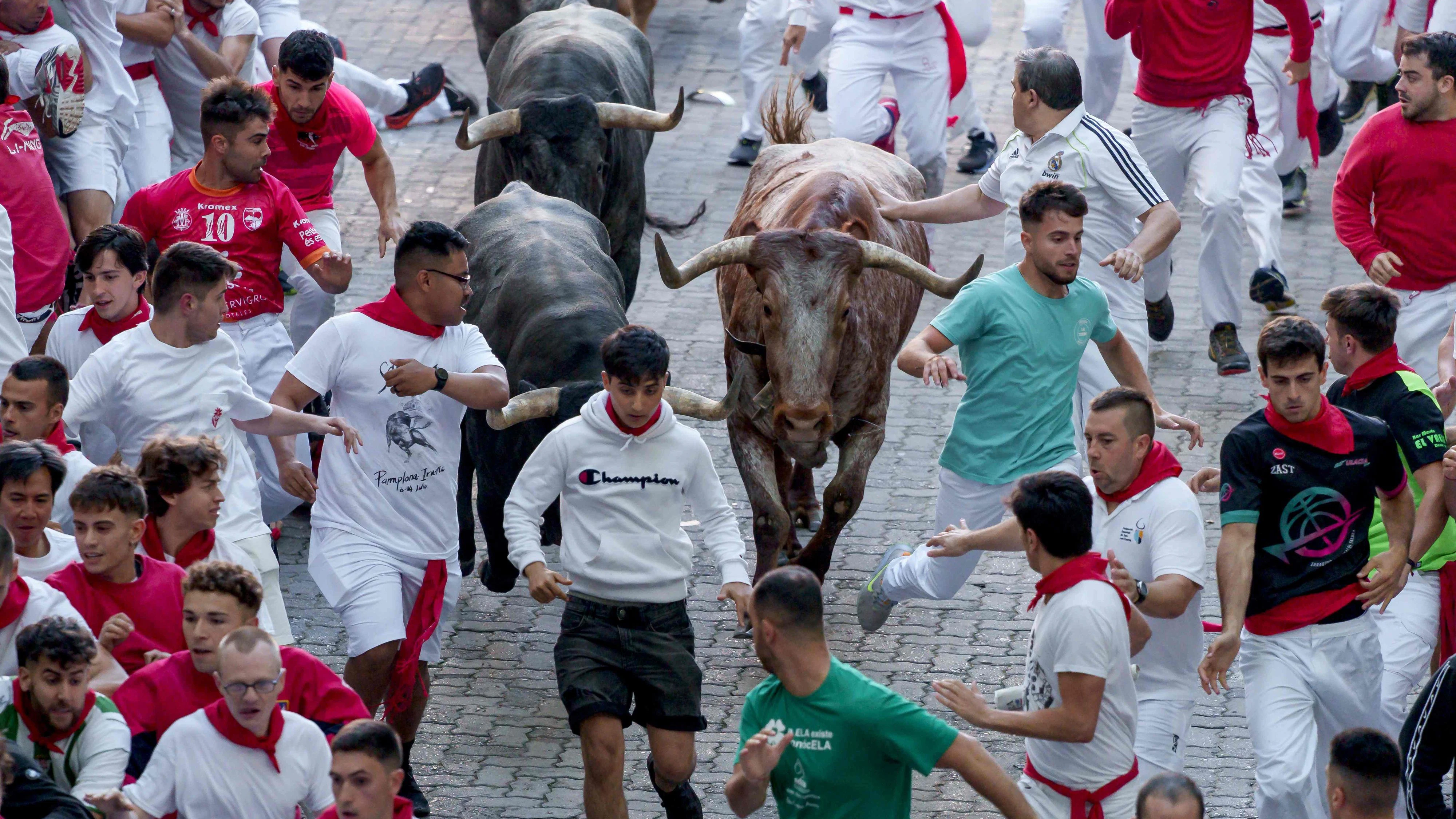 Download von www.picturedesk.com am 08.07.2023 (14:42).  Participants run ahead of bulls during the "encierro" (bull-run) of the San Fermin festival in Pamplona, northern Spain, on July 8, 2023. Thousands of people every year attend the week-long festival and its famous 'encierros': six bulls are released at 8:00 a.m. evey day to run from their corral to the bullring through the narrow streets of the old town over an 850 meters (yard) course while runners ahead of them try to stay close to the bulls without falling over or being gored. (Photo by CESAR MANSO / AFP) - 20230708_PD1259 - Rechteinfo: Rights Managed (RM) Nur für redaktionelle Nutzung! Werbliche Nutzung erfordert Freigabe: bitte schicken Sie uns eine Anfrage.