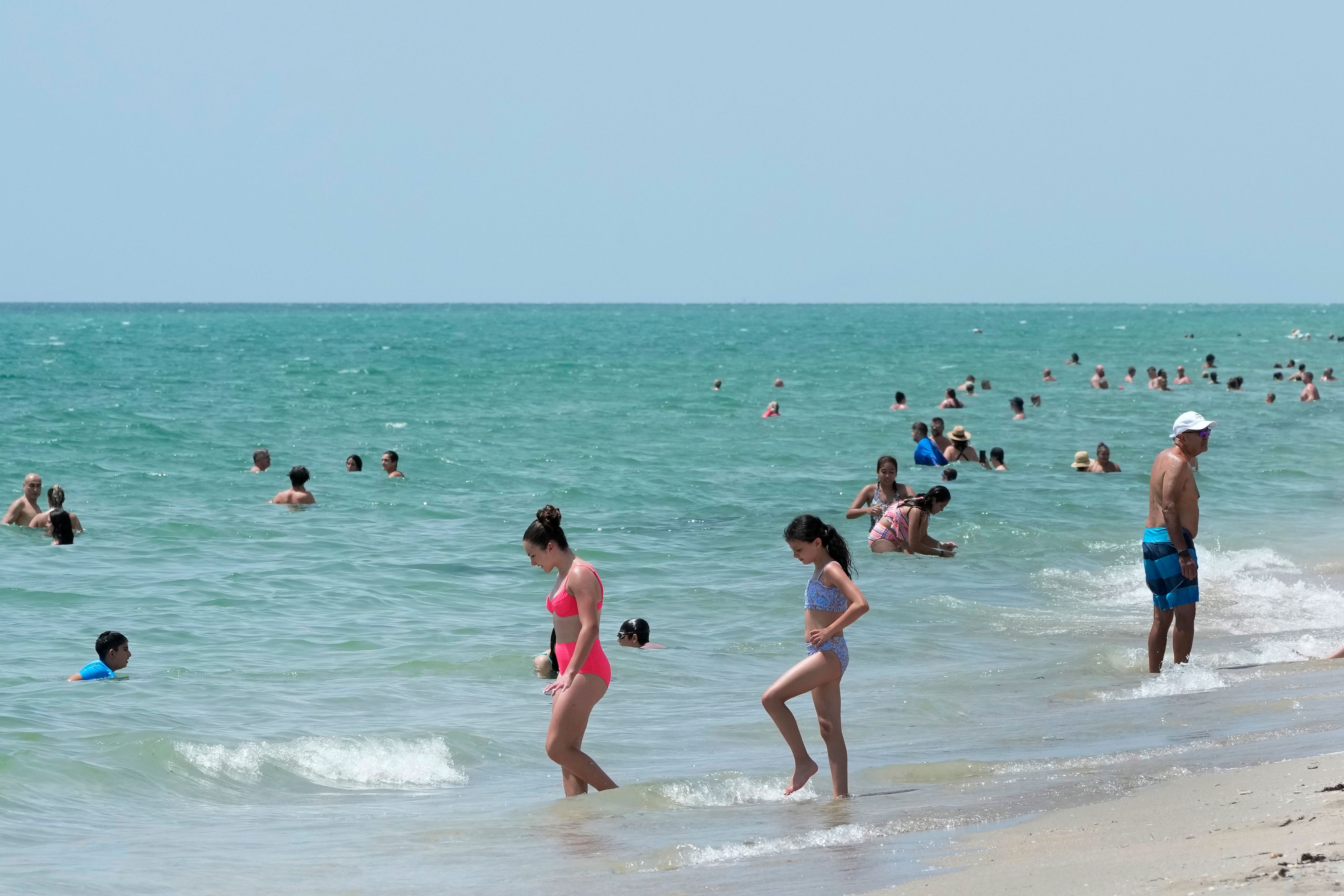 Beach goers take a dip in the Atlantic Ocean at Hollywood Beach, Monday, July 10, 2023, in Hollywood, Fla. The world's oceans are already record hot, especially the Atlantic, water surrounding much of Florida is in the 90s, hitting 96 degrees Fahrenheit around the keys. (AP Photo/Wilfredo Lee) - 20230710_PD7139 - Rechteinfo: Rights Managed (RM)