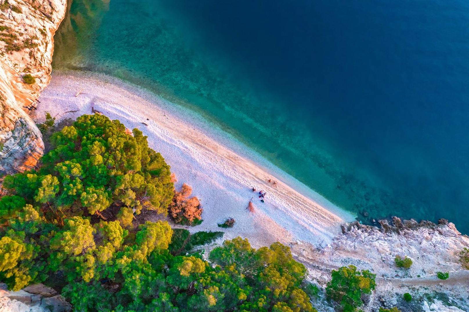 <strong>Nugal Beach nahe Makarska, Kroatien:</strong> Versteckt und ziemlich abgelegen liegt der Nugal Beach, in der Nähe der kroatischen Stadt Makarska – gerade richtig für einen FKK-Badeort. Der weiße, feine Kieselstrand schmiegt sich entlang einer felsigen Küste neben einem Waldgebiet und liegt direkt vor der blau glitzernden Adria. Die versteckte Bucht erreichst du am besten nach einem halbstündigen Spaziergang durch den Waldpark Osejava. Alternativ reist du per Boot zum Traumstrand. Wichtig zu wissen: Eine Strandbar suchst du hier vergeblich.&nbsp;