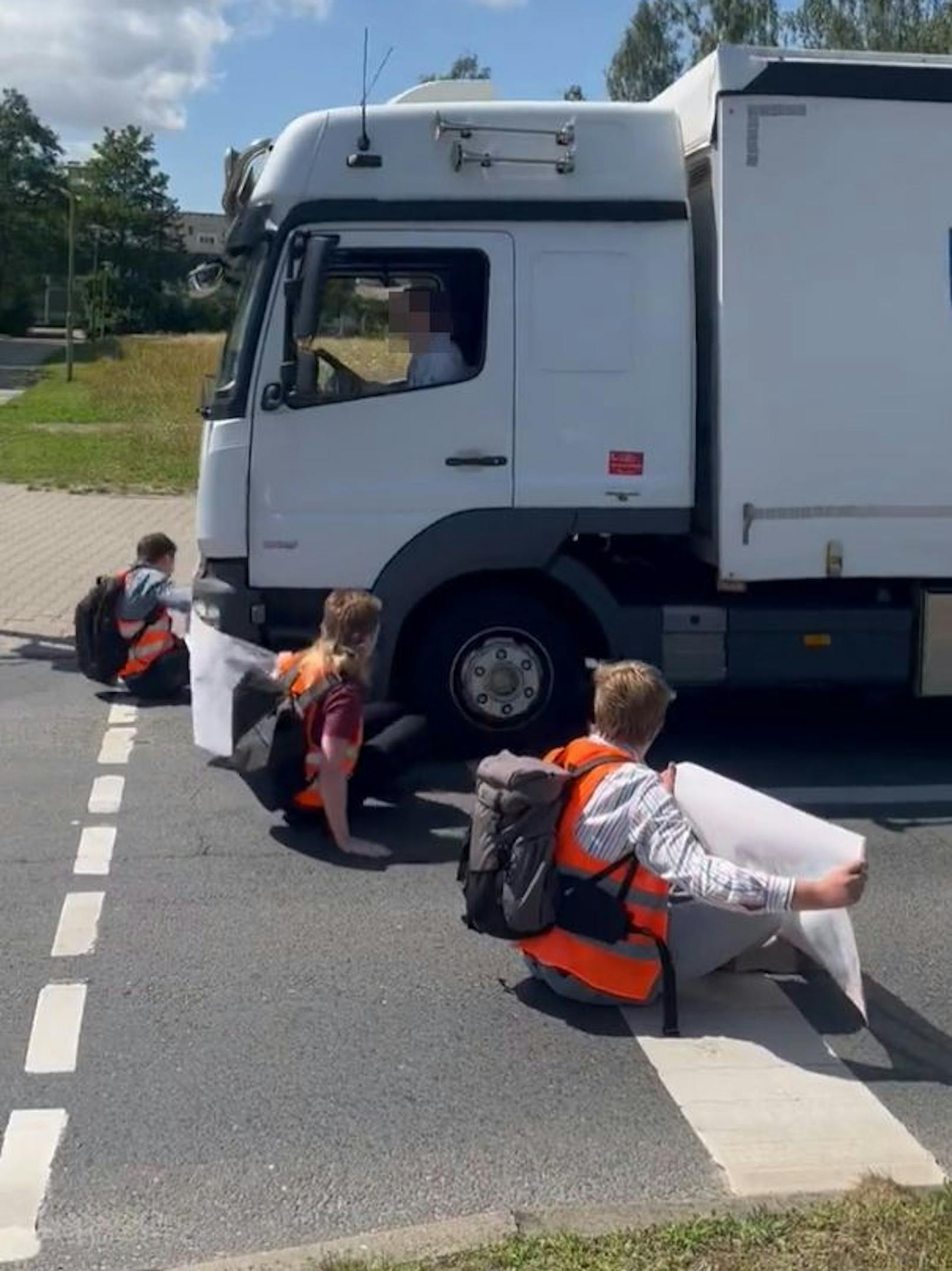 Eskalation in Stralsund am 12. Juli 2023: Ein Lkw-Lenker fuhr absichtlich mitten in die Straßenblockade der Letzten Generation, drohte den Aktivisten mit Faustschlägen. Vor den Augen mehrerer Volksschüler.