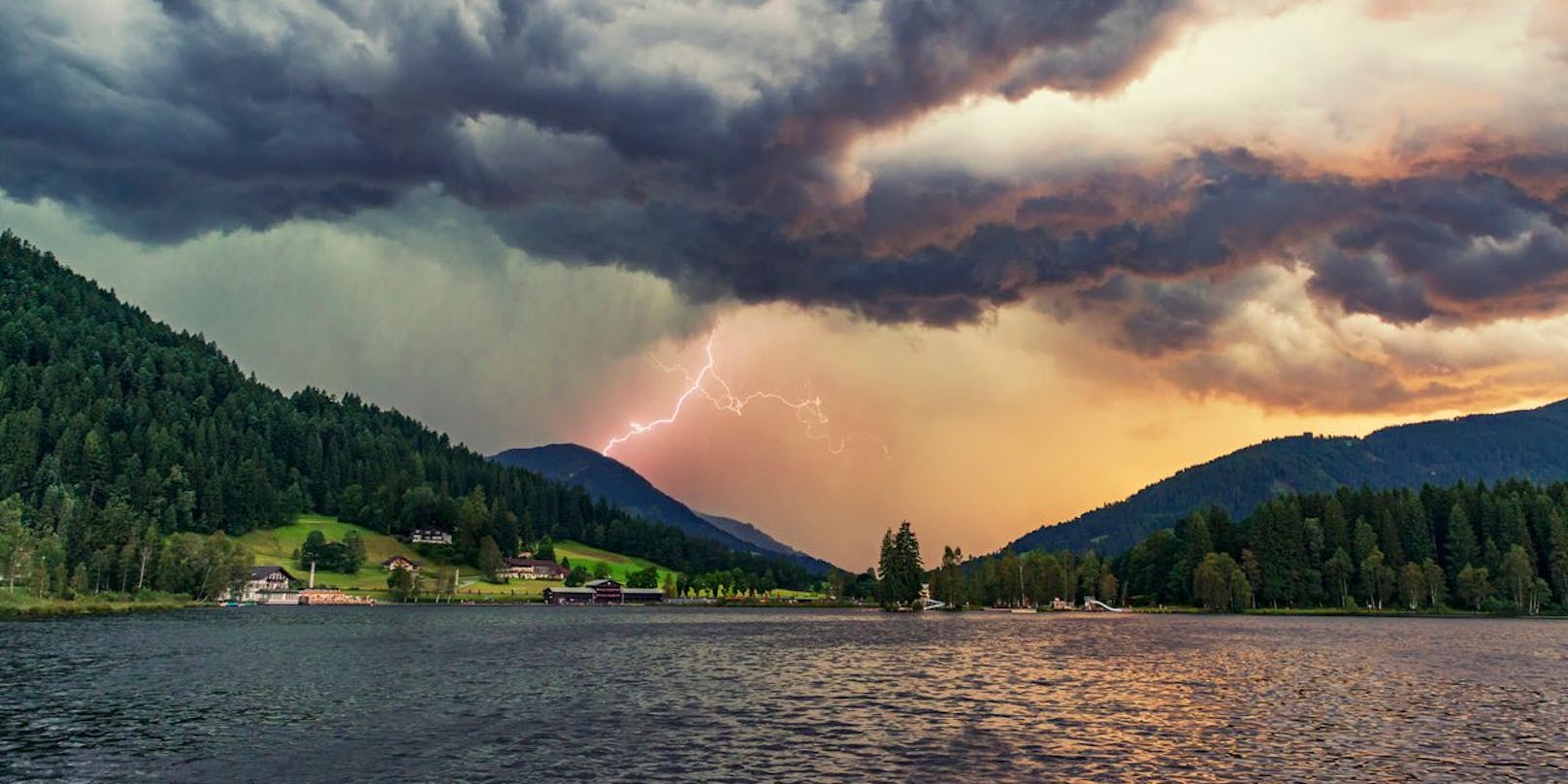 Dramatic thunderstorm with lightning and heavy rain at the lake