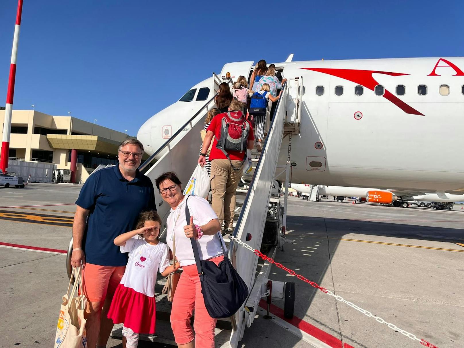 Sandra und Kurt Pfeil-Ehrengruber mit Enkelin Paulina vor der AUA-Maschine.