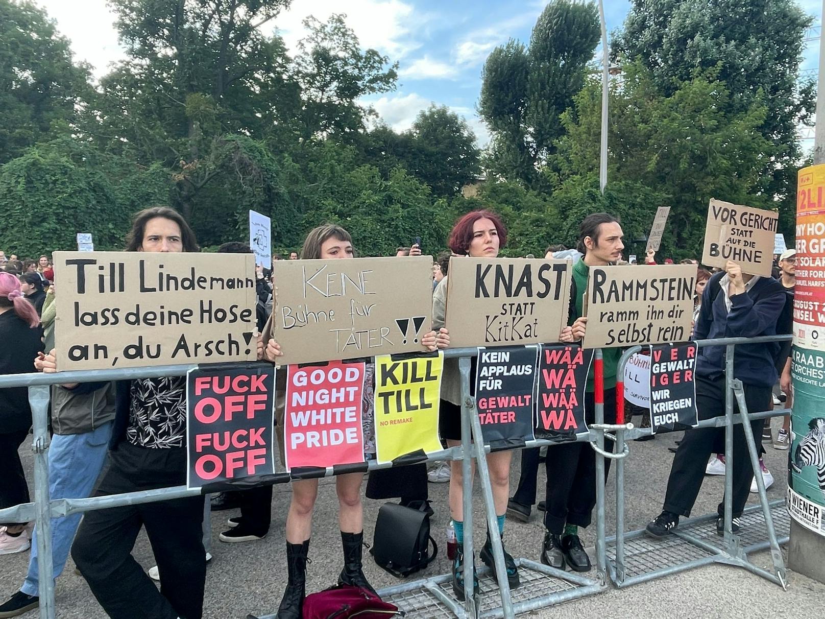 Die Demonstranten richten sich mit ihren Schildern ganz klar gegen die Rockband.