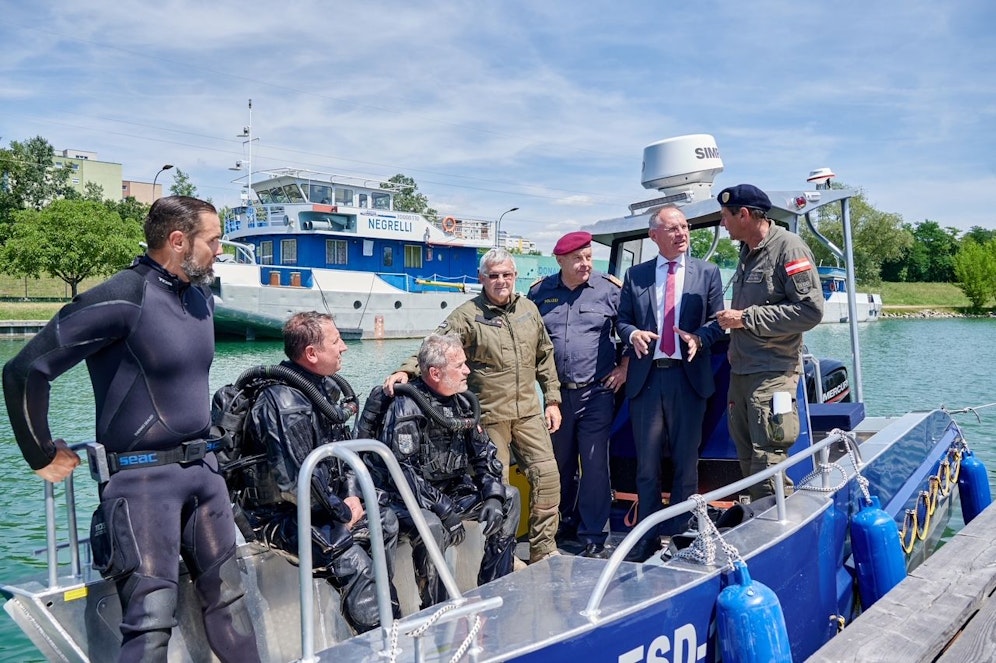 Innenminister Gerhard Karner und DSE-Direktor Bernhard Treibenreif mit Spezialisten und Tauchern des Entschärfungsdienstes im Rahmen einer Übung im Kremser Behördenhafen.