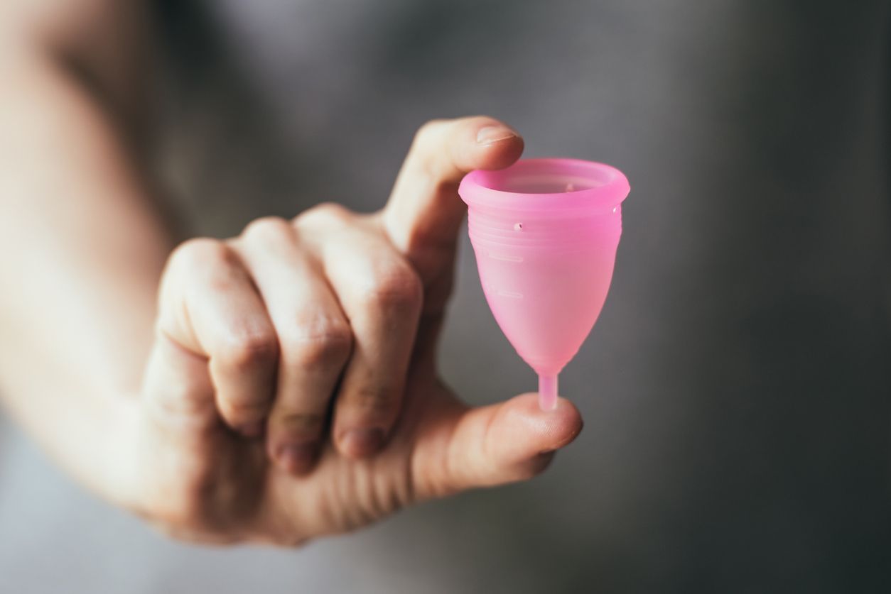 Young woman hand holding menstrual cup. Selective focus and shallow DOF